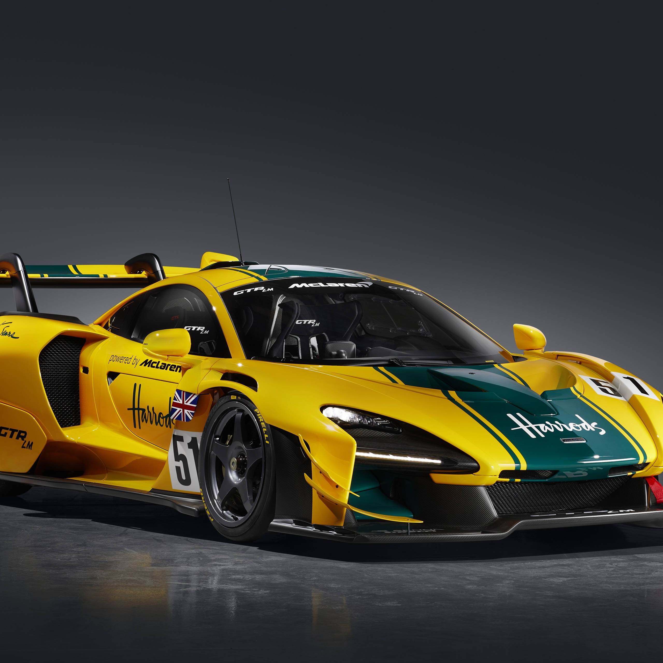 汽車 桌布 壁紙 — 一輛鮮豔的黃綠色McLaren Senna GTR LM賽車，編號51，帶有Harrods品牌標誌，在黑暗的攝影棚中擺拍。