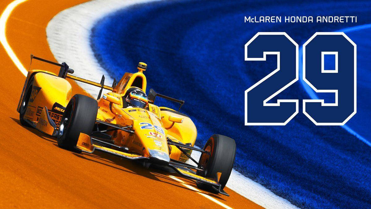Indianapolis 桌布 壁紙 — 一輛鮮黃色的McLaren Honda Andretti賽車在橙色賽道上高速過彎，帶有強烈的藍色動態模糊，並突出顯示29號。