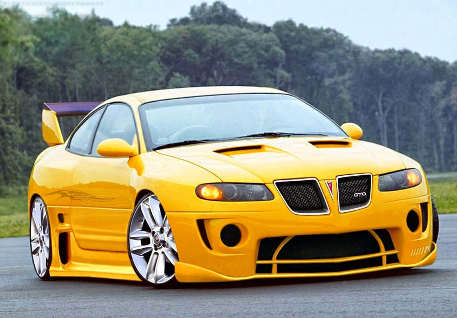 Yellow Car 桌布 壁紙 — 一輛鮮黃色的Pontiac GTO跑車，帶有紫色尾翼，停泊在一條被綠樹環繞的瀝青路上。