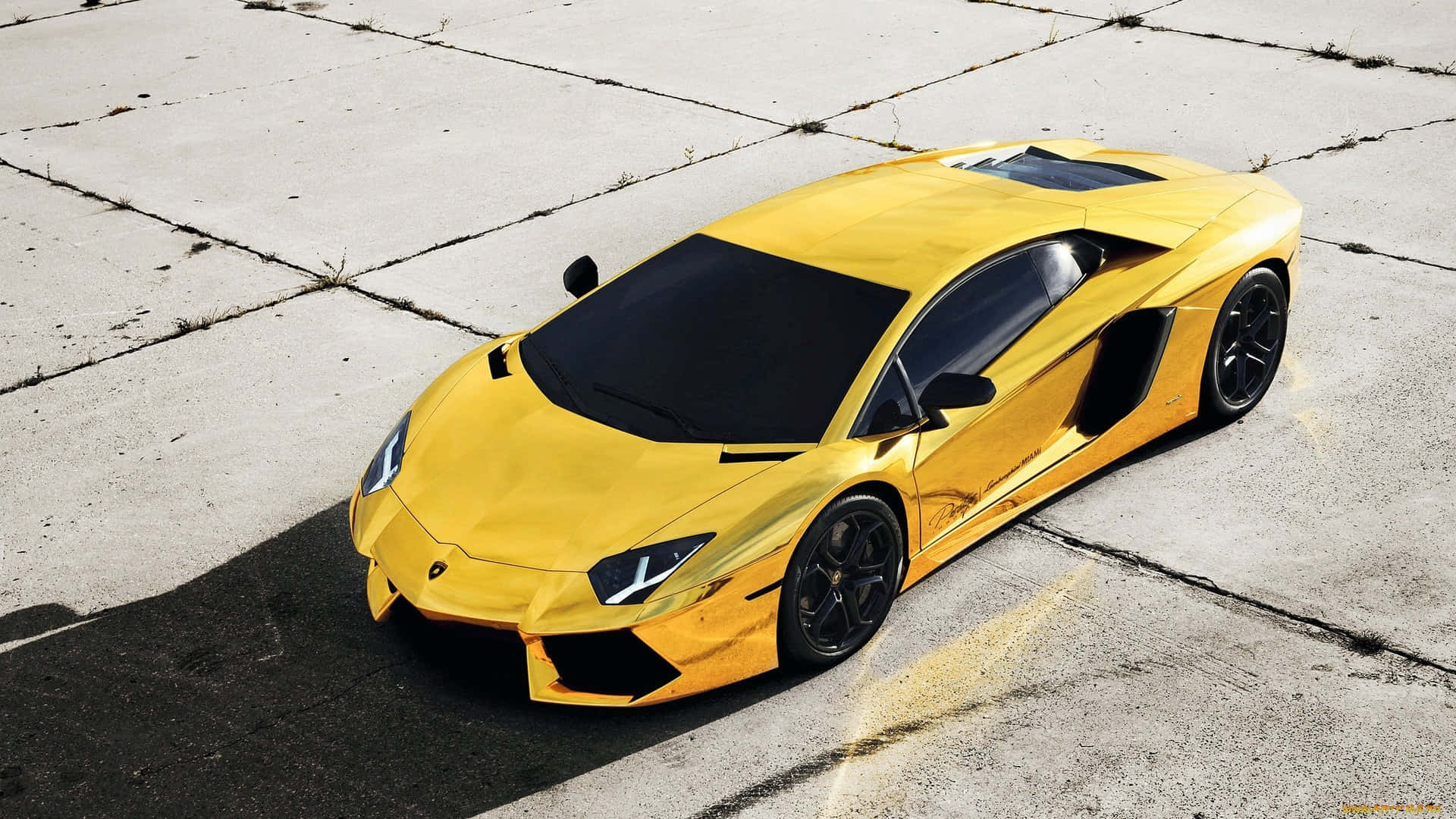 跑車 桌布 壁紙 — 一輛鮮黃色的藍寶堅尼 Aventador 跑車在明亮的陽光下，於龜裂的混凝土表面上閃閃發光。
