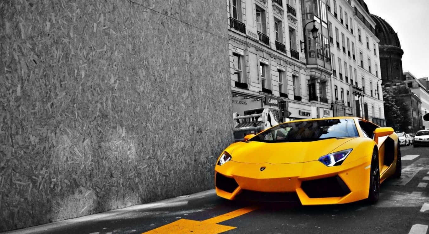 Yellow Car 桌布 壁紙 — 一輛鮮黃色的藍寶堅尼Aventador停放在黑白背景的城市街道上。