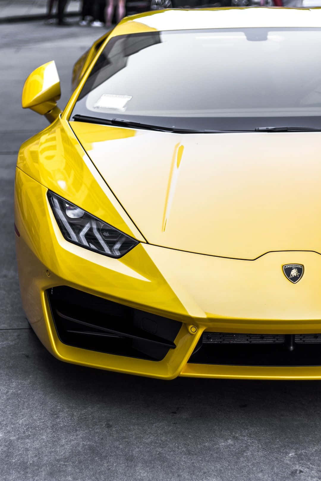 Pixel 3xl Lamborghini 桌布 壁紙 — 一輛鮮黃色藍寶堅尼跑車的特寫，具有銳利的棱角線條和光澤飾面，停在混凝土上。