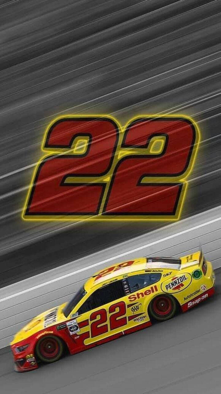 Joey Logano 桌布 壁紙 — 一輛黃色和紅色的22號賽車在賽道上疾馳，身後留下動態模糊的痕跡。