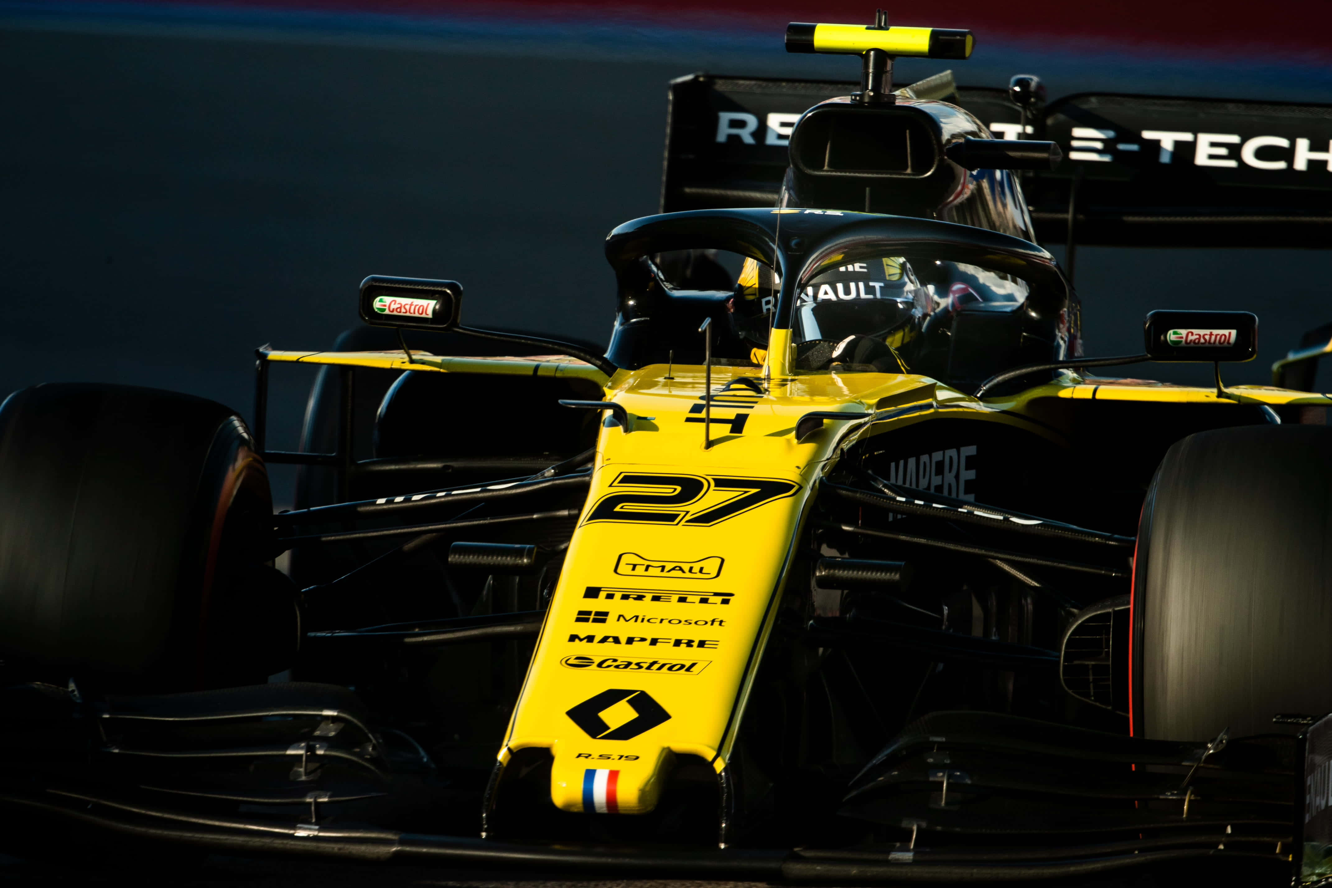 F1 2019 壁紙 桌布 壁紙 — 一輛黃黑相間、編號27的一級方程式賽車在明亮燈光下於賽道上疾馳的特寫。