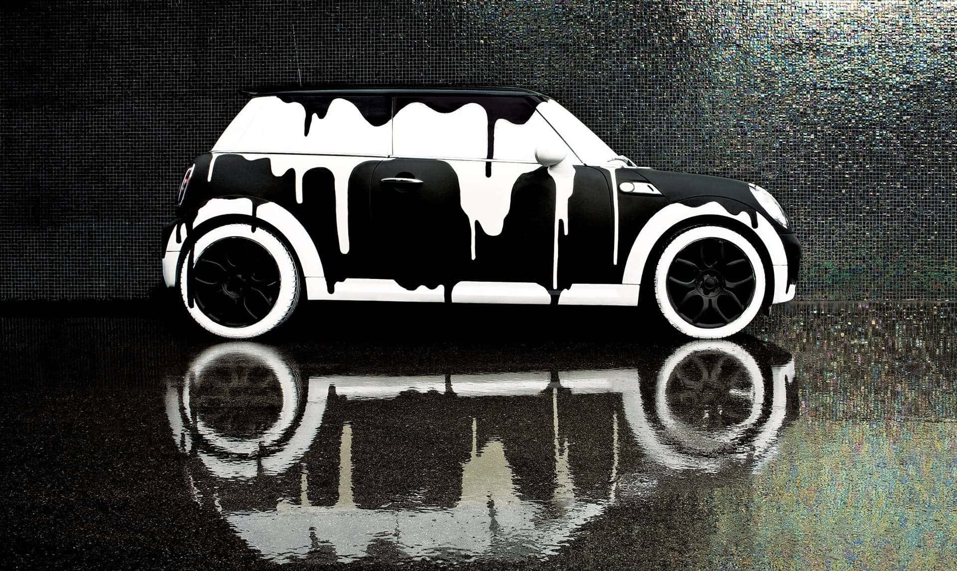 洗車 桌布 壁紙 — 一輛黑白相間的Mini Cooper，油漆滴落，停在濕漉漉的反光表面上，背景是像素化牆壁。