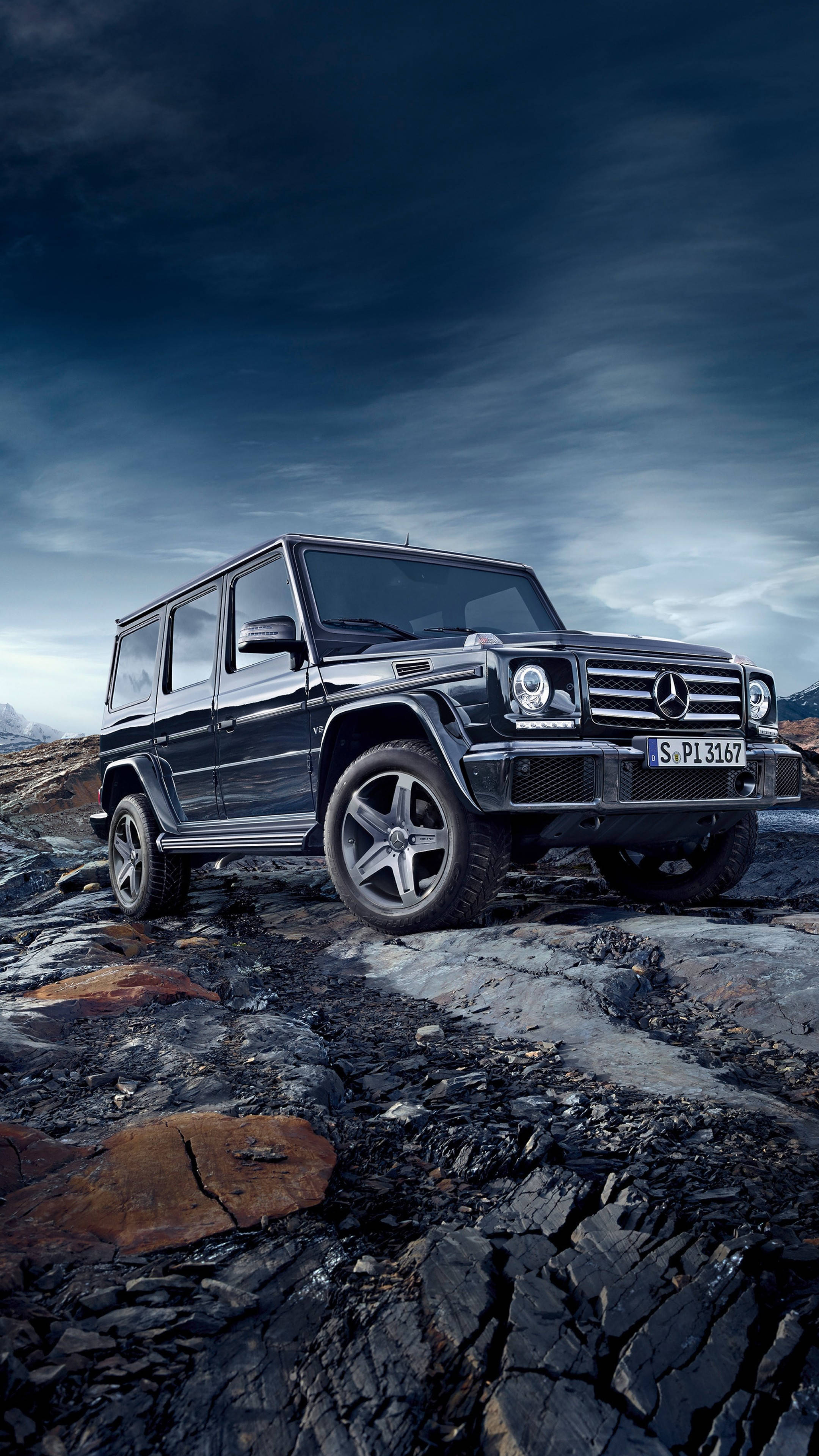 mercedes iPhone 桌布 壁紙 — 一輛黑色 Mercedes G-Class SUV 在戲劇性的暴風雨天空下，堅毅地矗立在龜裂的火山岩上。