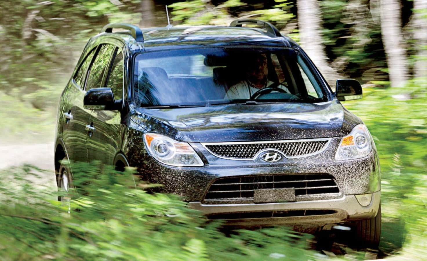 Hyundai Veracruz 桌布 壁紙 — 一輛黑色Hyundai SUV在泥濘的森林小徑上行駛，周圍有動態模糊效果。