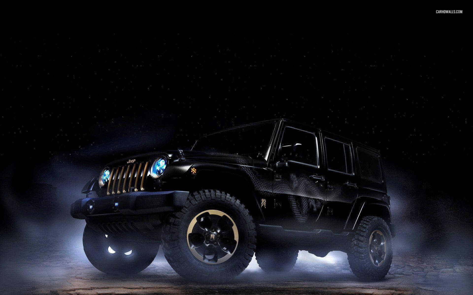 吉普 桌布 壁紙 — 一輛黑色Jeep Wrangler，帶有發光的藍色頭燈和金色飾邊，在星空下的薄霧中戲劇性地矗立。