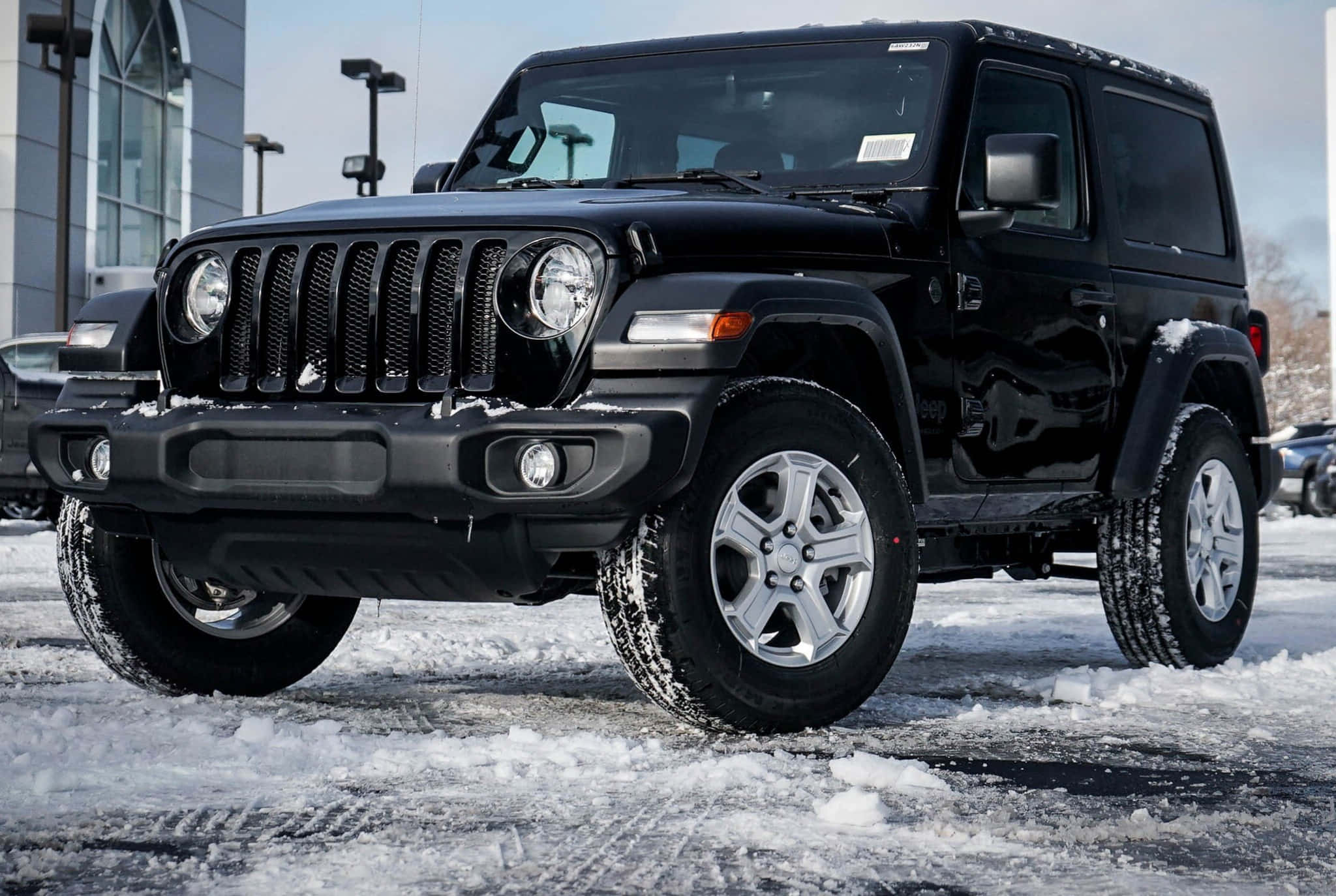 黑色吉普車 桌布 壁紙 — 一輛黑色Jeep Wrangler在晴朗的冬日天空下，勇敢地停在積雪的停車場上。