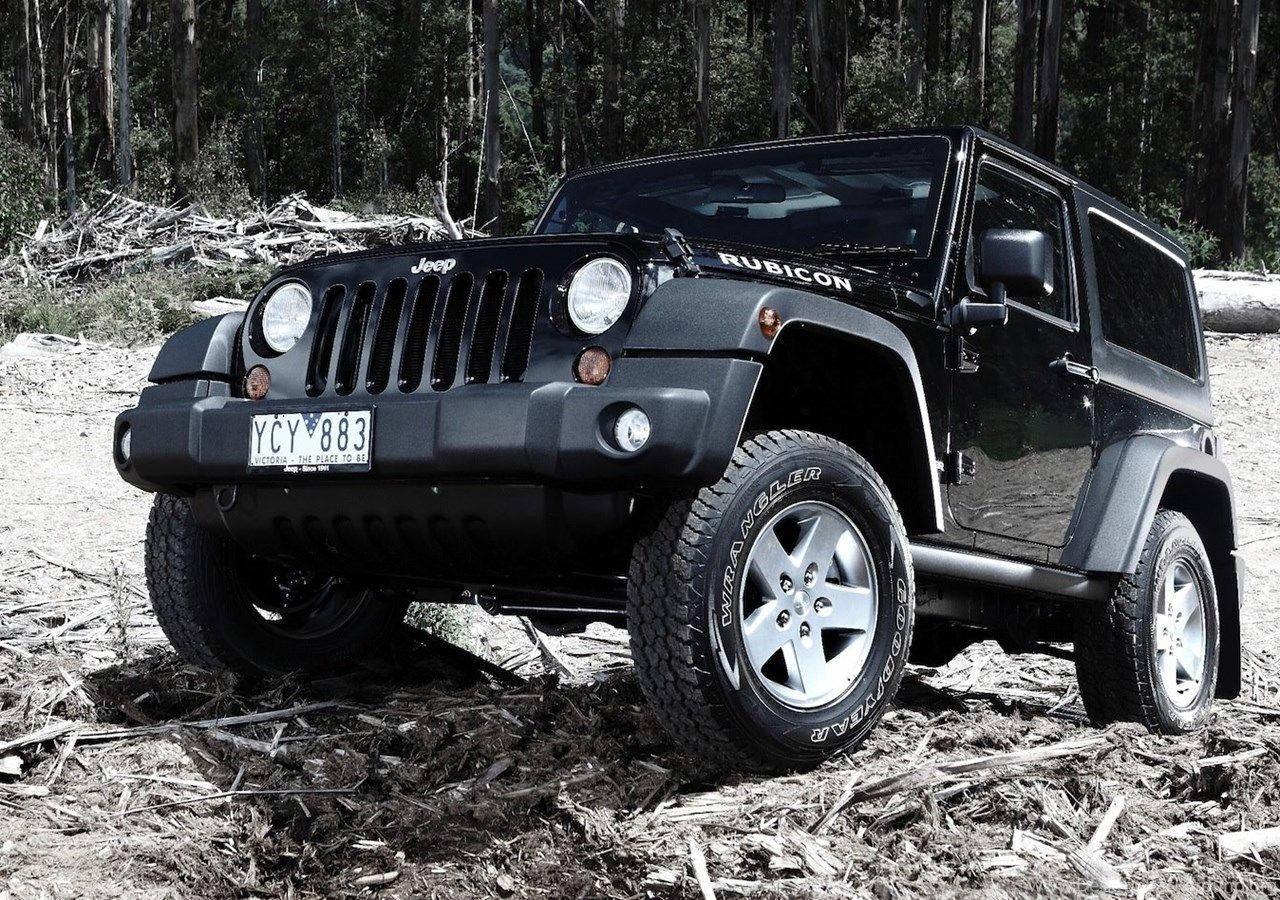 Wrangler 桌布 壁紙 — 一輛黑色Jeep Wrangler Rubicon在佈滿落枝和泥土的森林小徑上堅固地矗立。