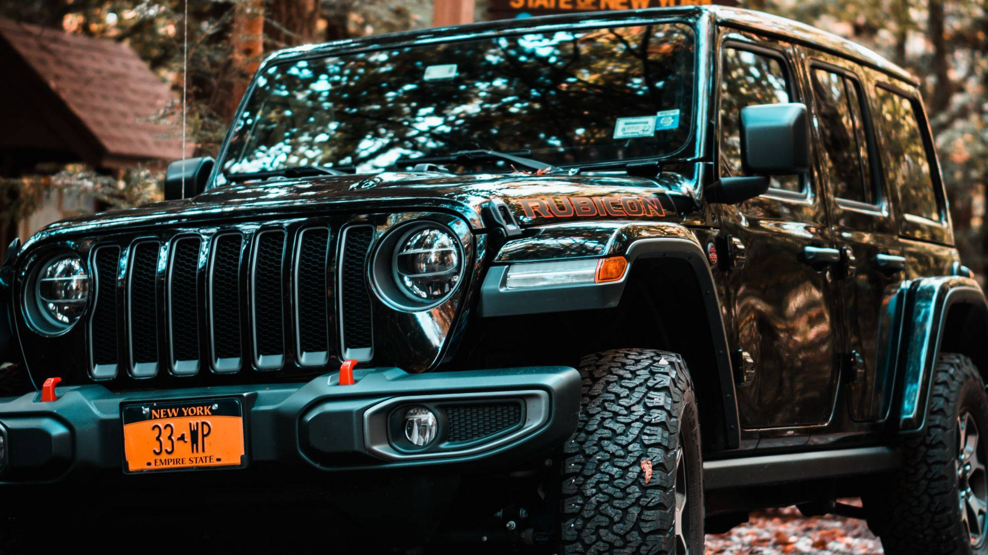 Black Jeep 桌布 壁紙 — 一輛黑色Jeep Wrangler Rubicon掛有紐約車牌，停泊在落葉滿地的森林區域。