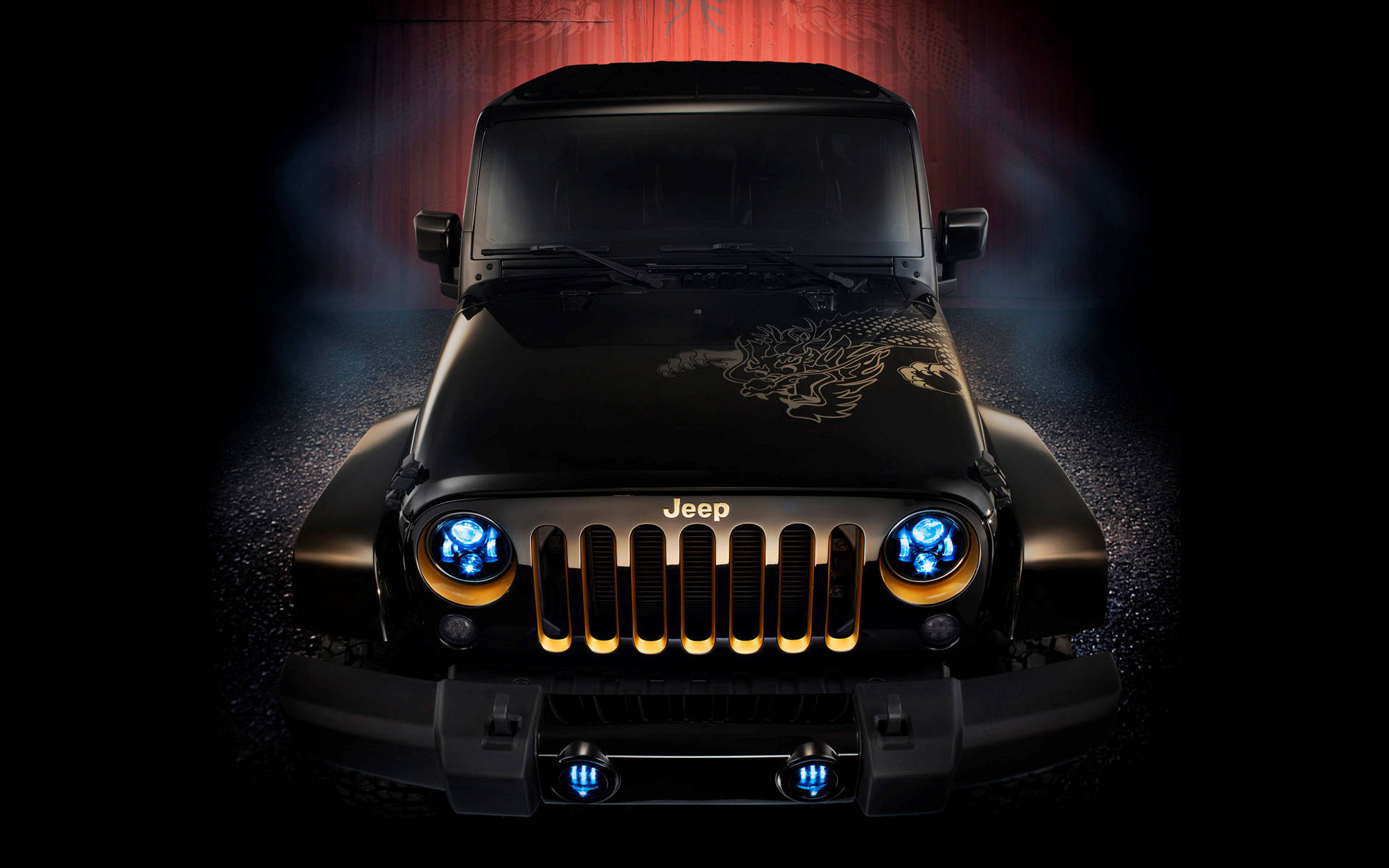 黑色吉普車 桌布 壁紙 — 一輛黑色Jeep Wrangler，帶有發光的藍色頭燈和金色格柵飾件，在紅色環境燈光下顯得格外引人注目。