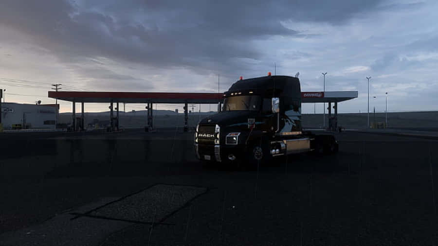 Simulation Games 桌布 壁紙 — 一輛黑色Mack卡車停放在加油站，背景是帶有烏雲的暮色天空。