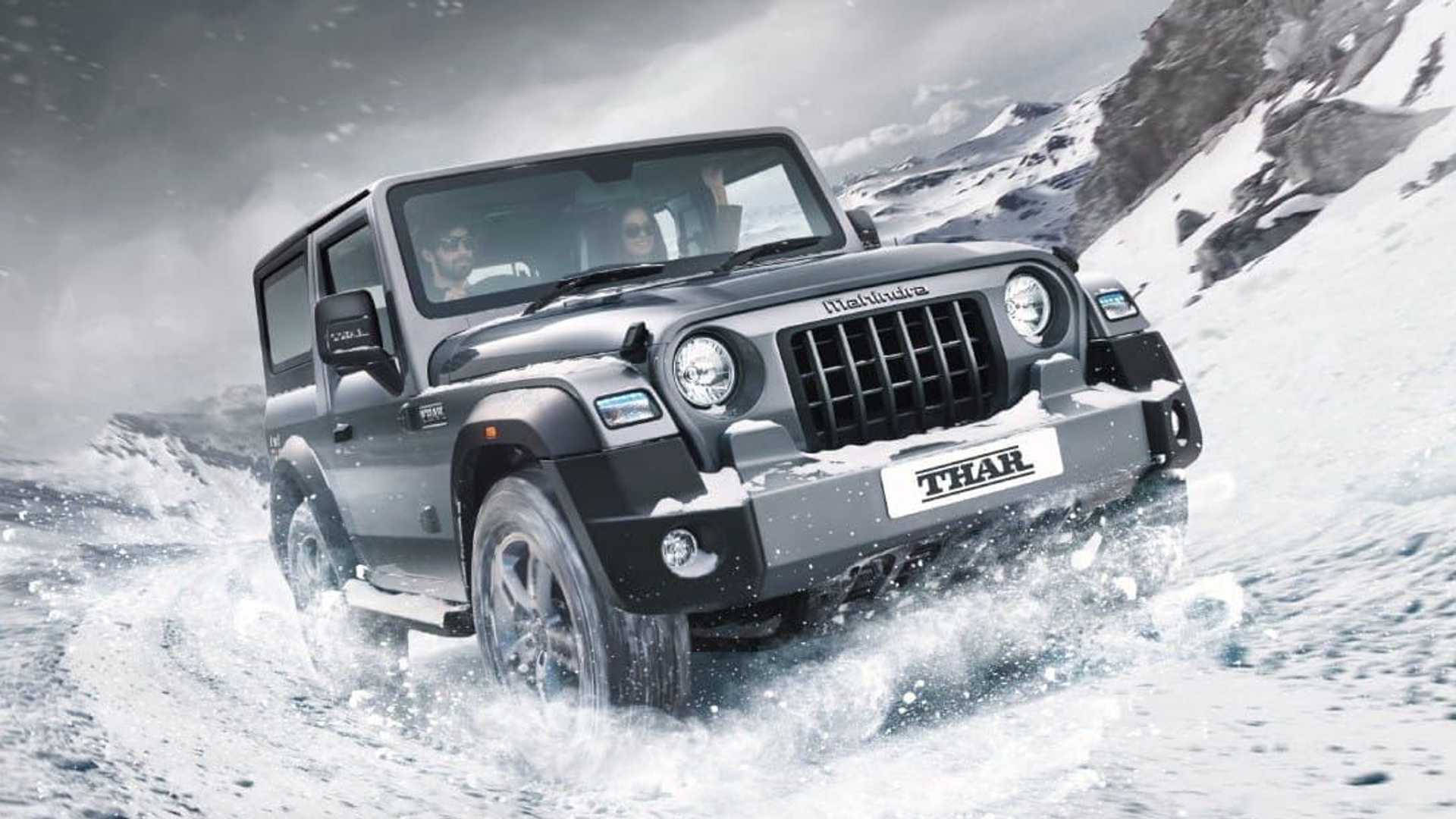 汽車 桌布 壁紙 — 一輛黑色Mahindra Thar SUV在積雪的山地地形上行駛，在多雲的天空下揚起雪霧。