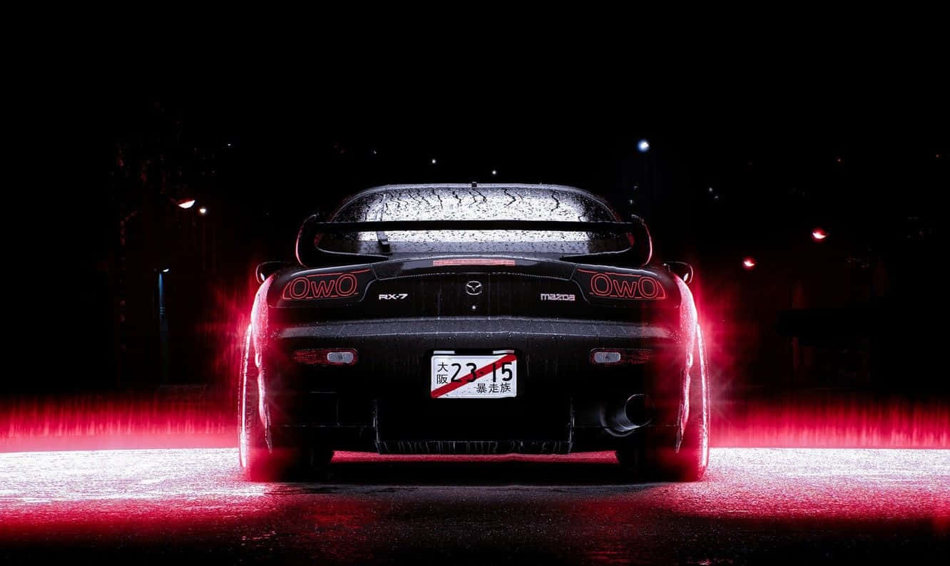 馬自達 桌布 壁紙 — 一輛黑色Mazda RX-7跑車在潮濕的夜街上閃爍著強烈的紅色尾燈，雨滴在後窗上閃閃發光。