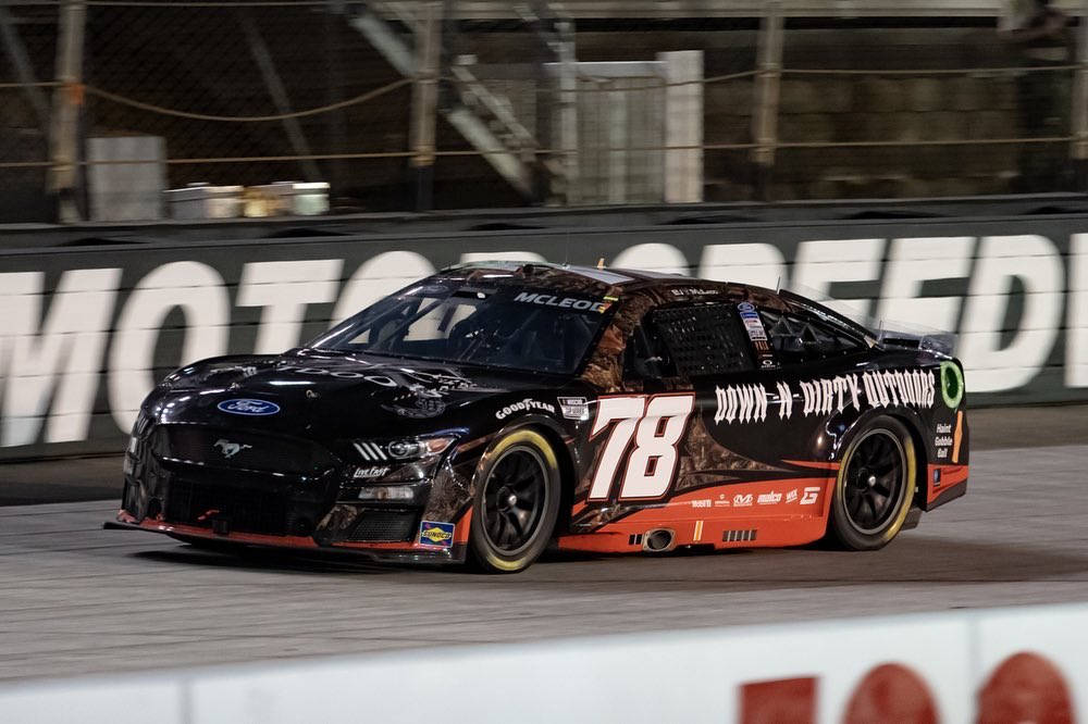 橘色 桌布 壁紙 — 一輛黑色和橙色的NASCAR賽車（78號）在明亮的體育場燈光下於夜間賽道上疾馳。