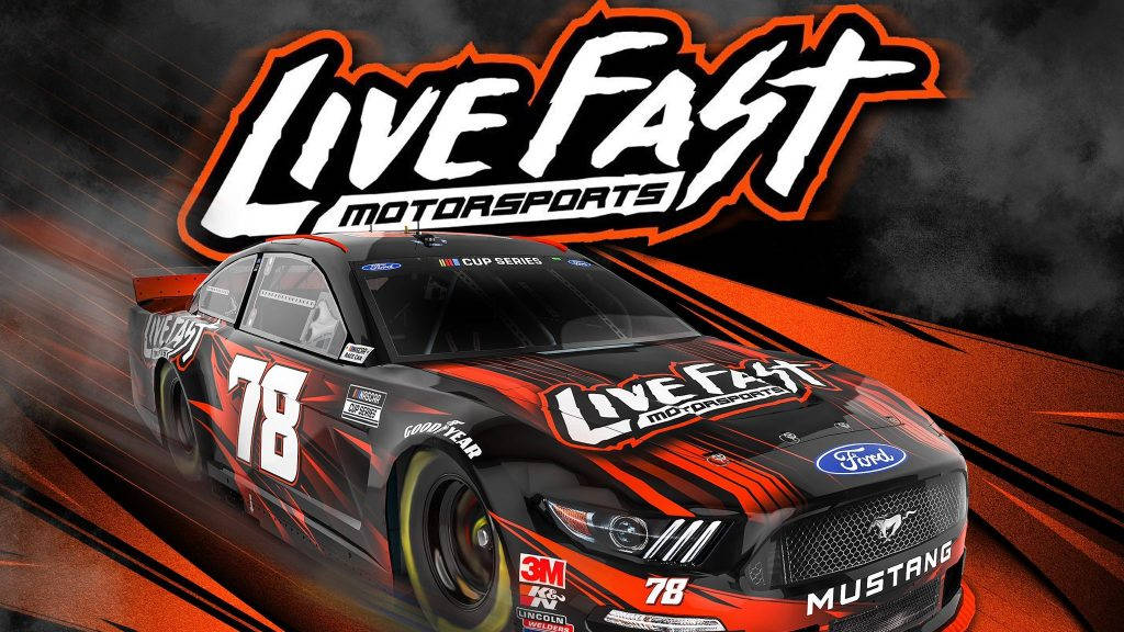 Racing 桌布 壁紙 — 一輛黑色和橙色的福特野馬賽車（編號78）在「Live Fast Motorsports」標誌下，穿過動態模糊背景飛馳。