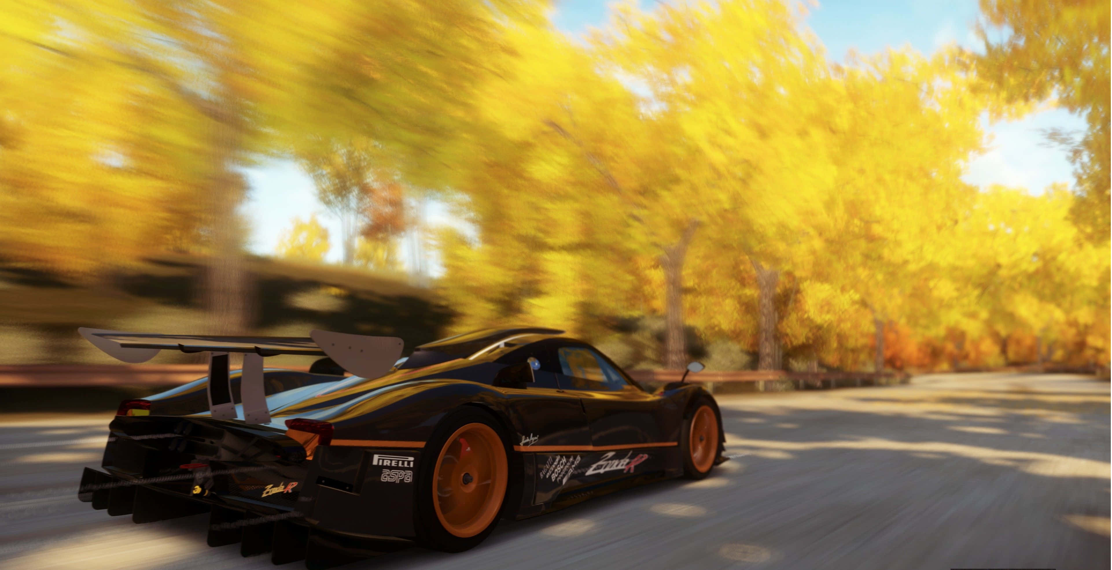 Racing Games 桌布 壁紙 — 一輛黑色和橙色的賽車穿過金色的秋日森林，帶有模糊的動感，陽光透過黃葉灑落。