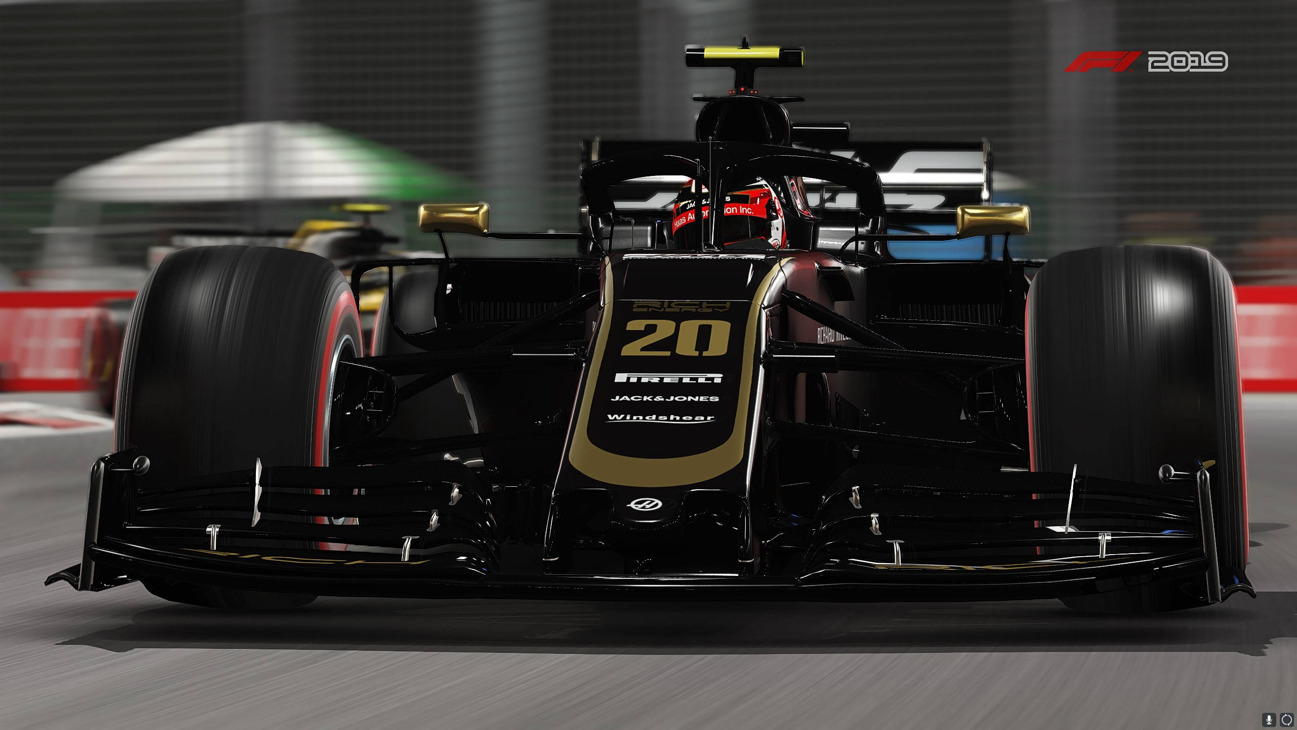 F1 2019 壁紙 桌布 壁紙 — 一輛黑色和金色的 Formula 1 賽車，號碼 20，在賽道上高速行駛，帶有模糊的動態效果和可見的贊助商標誌。