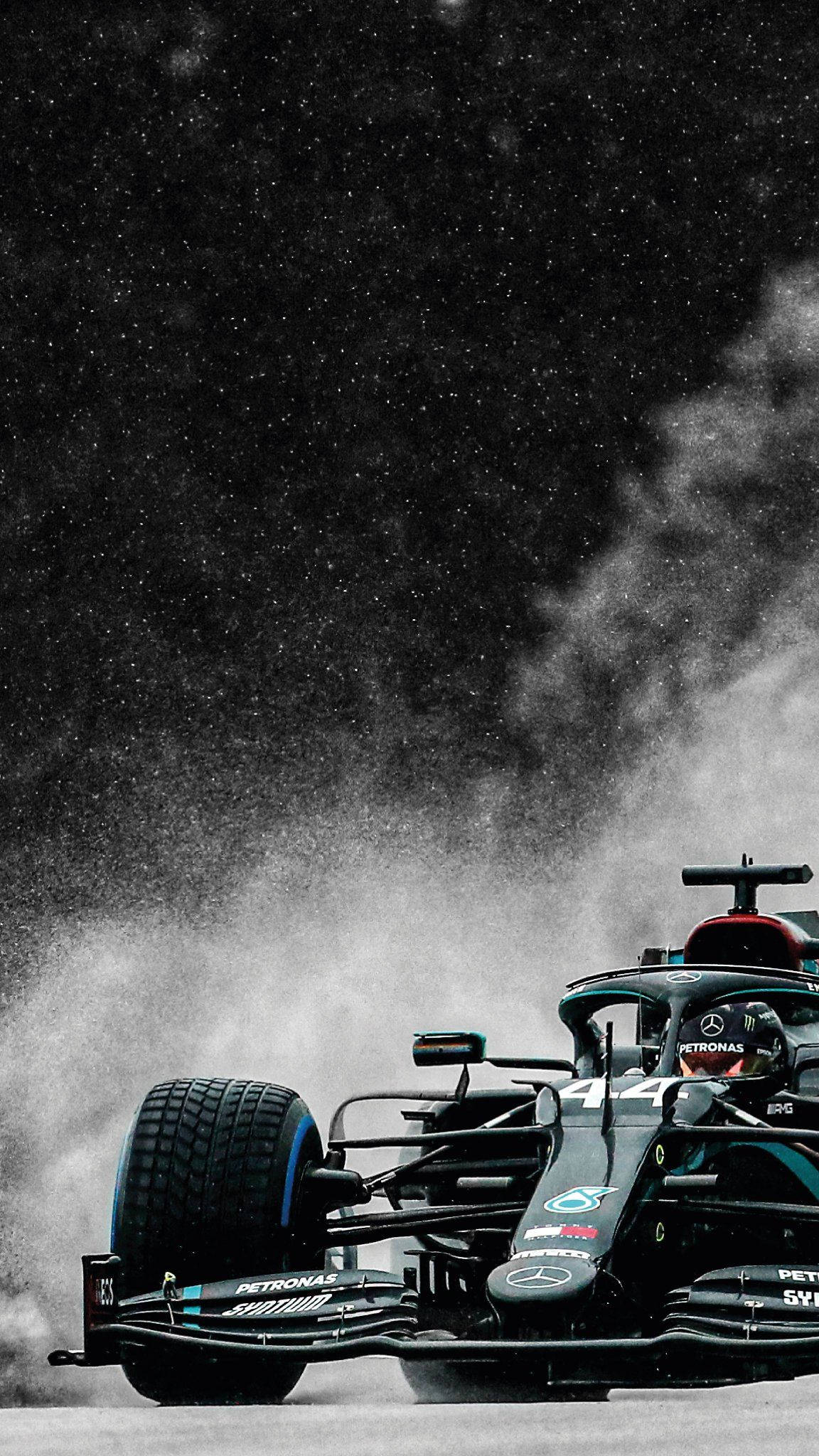 Mercedes 桌布 壁紙 — 一輛黑色和青綠色的F1賽車在星空下的濕滑賽道上激起水花。