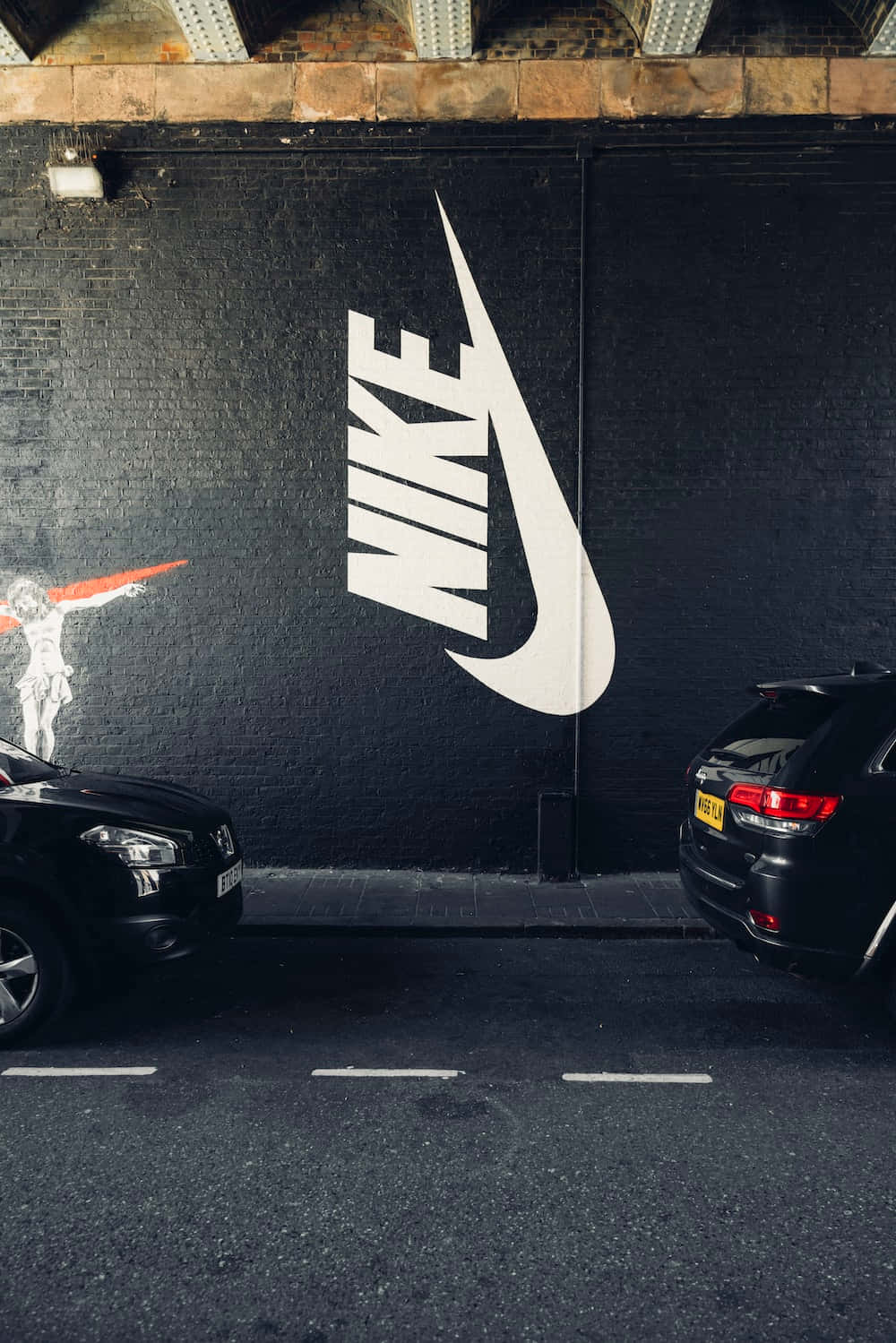 一輛黑色汽車停在Nike牆前 壁紙