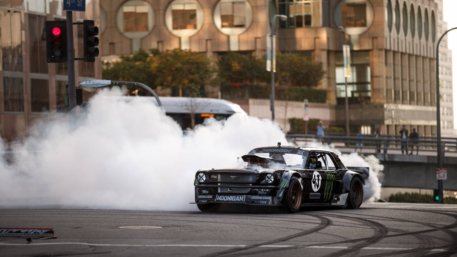 race car 桌布 壁紙 — 一輛黑色甩尾車在黃昏時分的城市街道上劃過彎道，冒出濃煙。