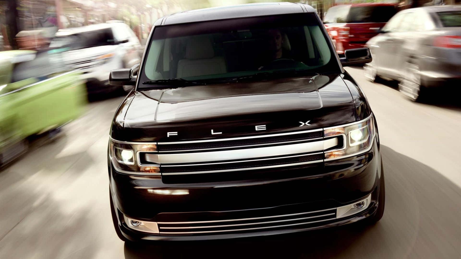 Ford Flex 桌布 壁紙 — 一輛黑色福特Flex SUV在繁忙的街道上向前行駛，周圍有因移動而模糊的汽車。