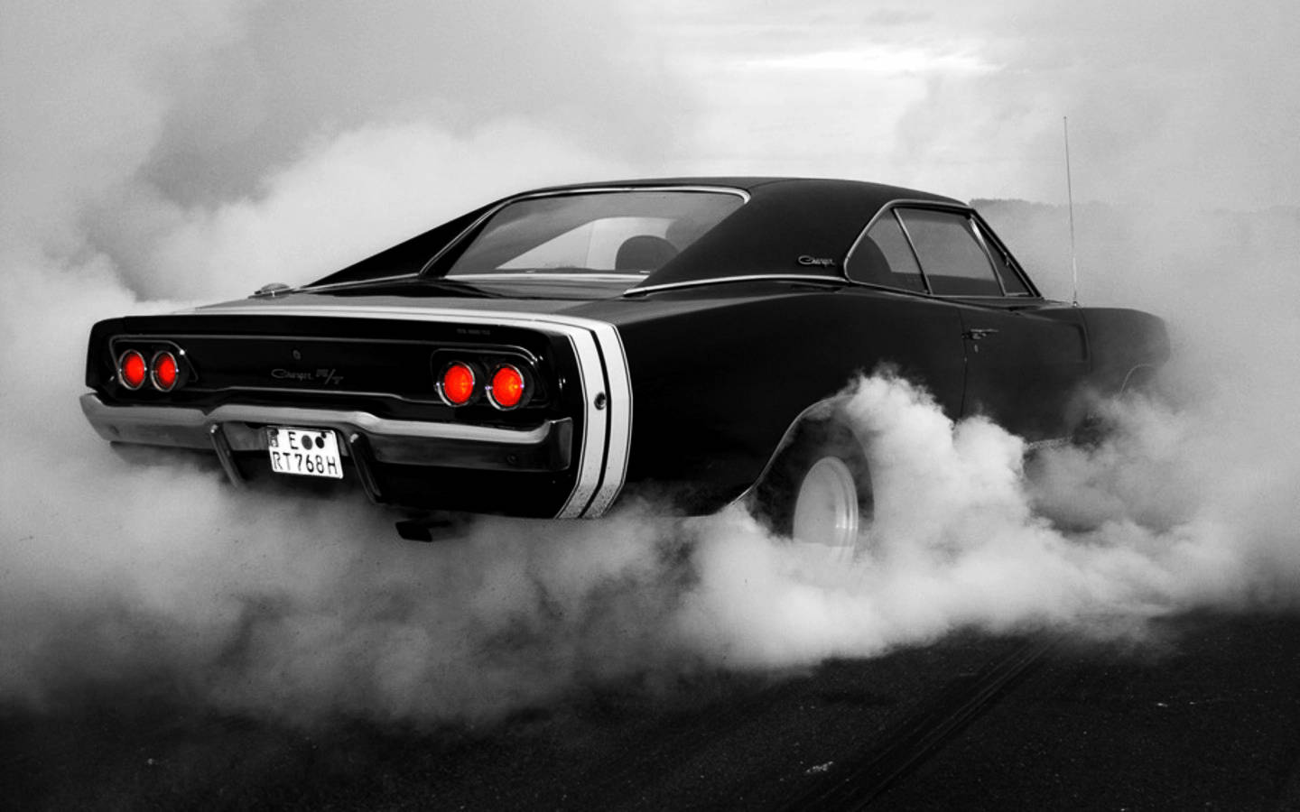 race car 桌布 壁紙 — 一輛黑色經典肌肉車，紅色尾燈，在黑暗的道路上燒胎，產生濃厚的煙霧。