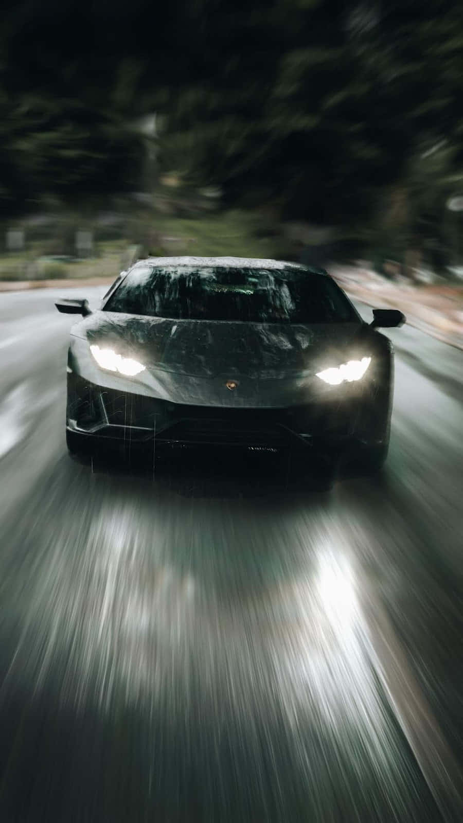 Pixel 3xl Lamborghini 桌布 壁紙 — 一輛黑色藍寶堅尼在夜雨中疾馳，車頭燈劃破濕漉漉路面和樹木的模糊動態。
