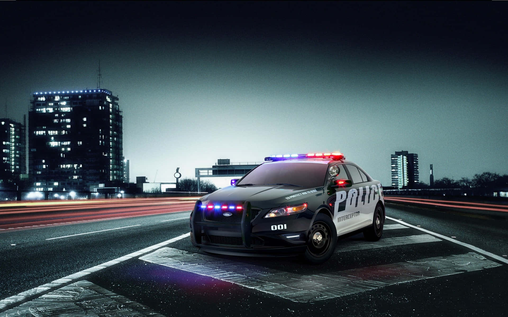 高清汽車 桌布 壁紙 — 一輛黑色警用攔截車閃著警燈，在夜間濕潤的城市高速公路上停下，背景是模糊的車流線條和燈火通明的摩天大樓。