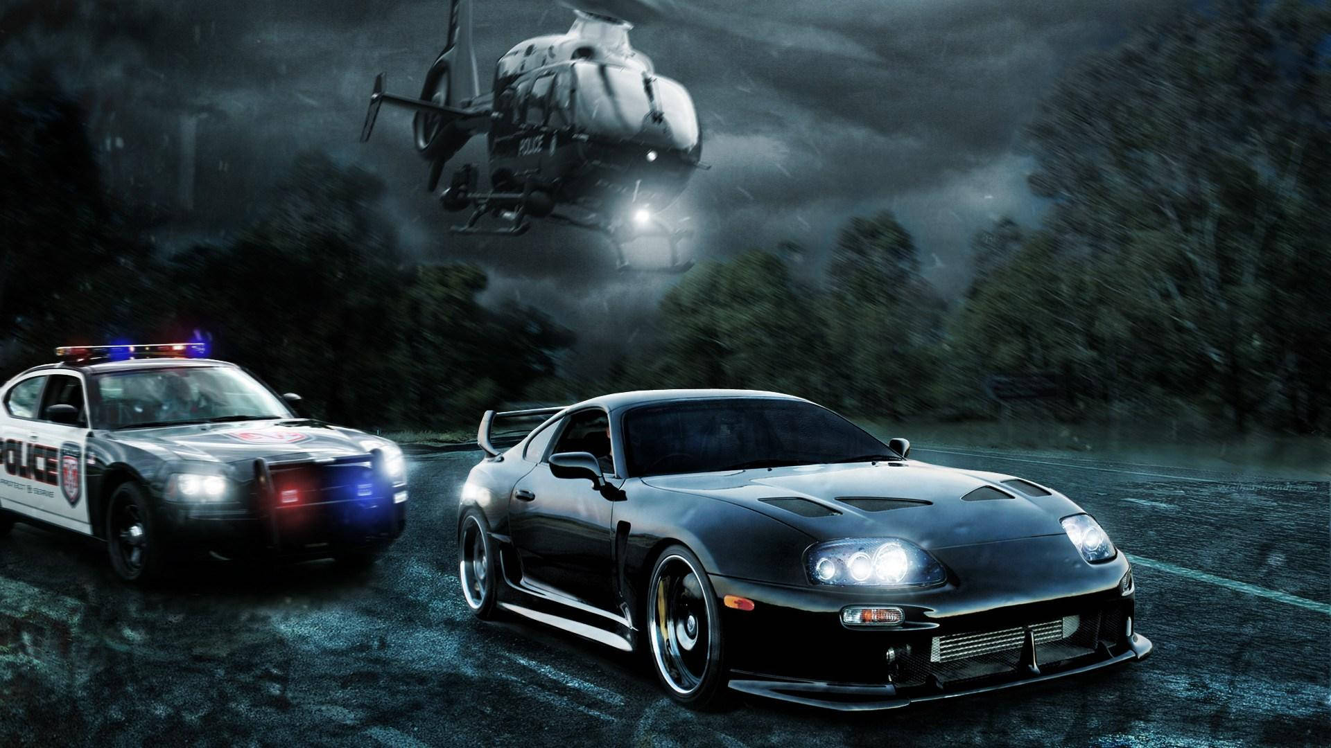 警察 桌布 壁紙 — 一輛黑色跑車在暴風雨的夜晚森林中逃離警車，一架警用直升機在上空盤旋。