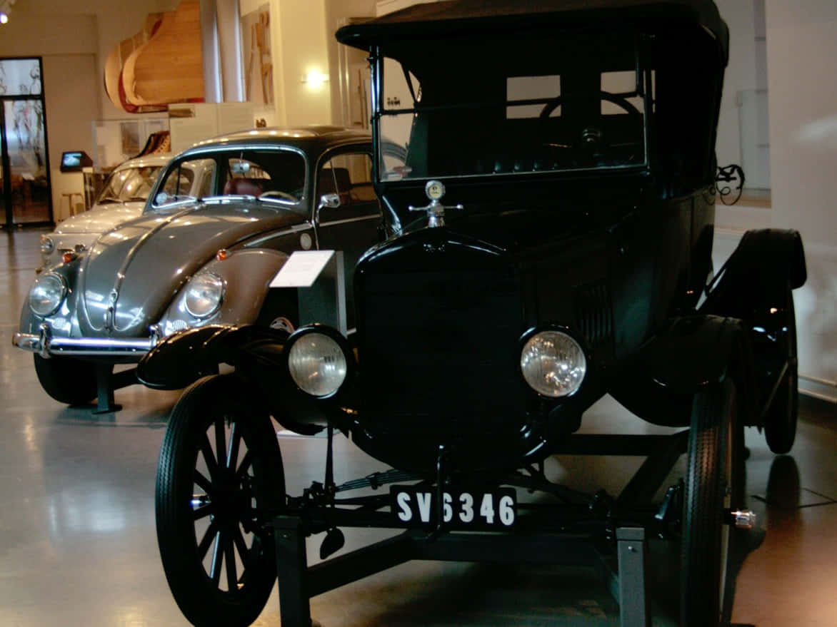 Ford Logo 桌布 壁紙 — 一輛黑色車牌SV6346的復古車在博物館中與一輛銀色經典福斯金龜車並列展示。