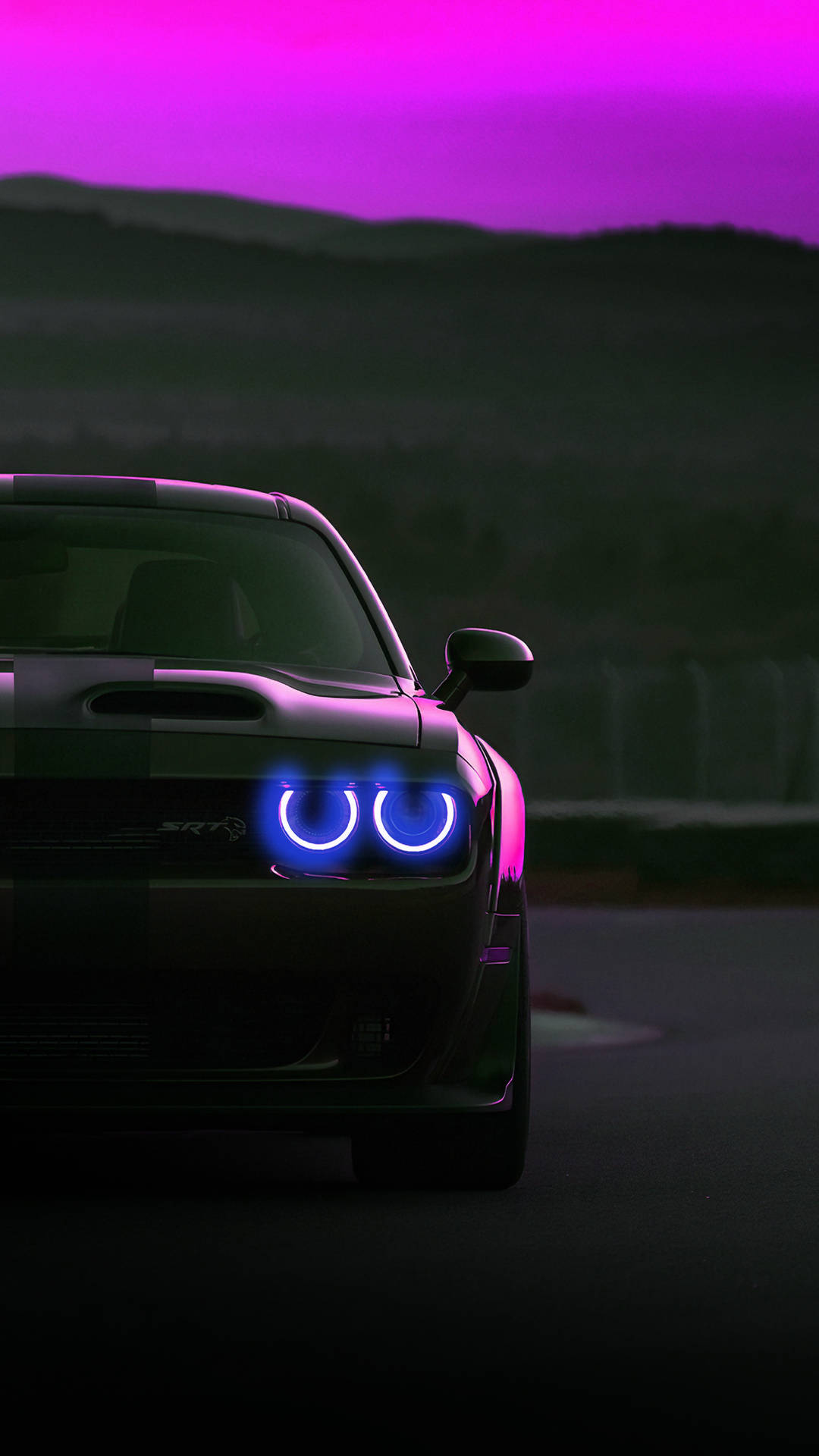 黑色道奇挑戰者SRT Hellcat，帶有發光的藍色頭燈，在黃昏時分的賽車場上。 — 紫色美學 壁紙