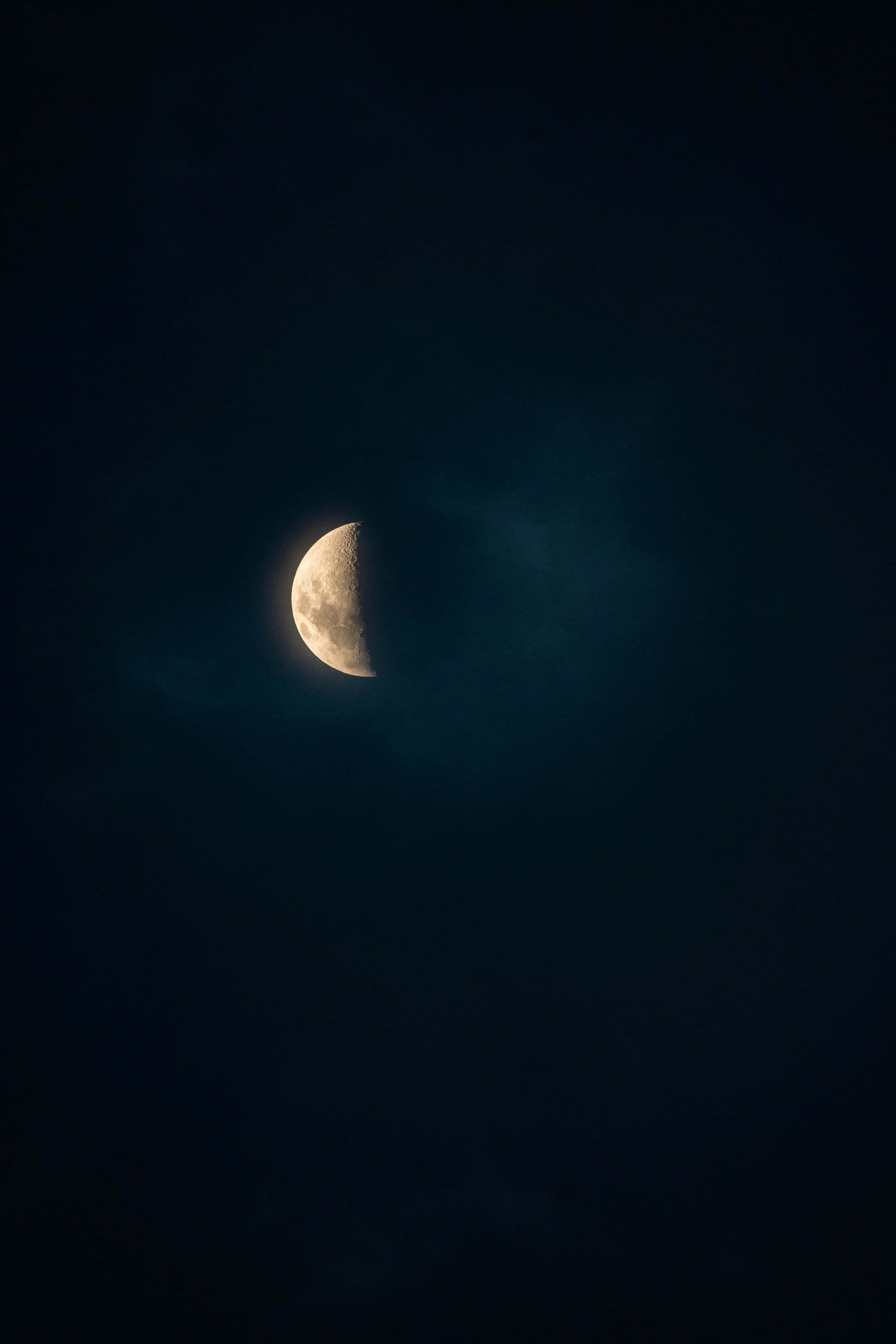 Aesthetic Sky 桌布 壁紙 — 一輪明亮的彎月在深靛藍色的夜空中，透過縷縷薄雲柔和地發光。