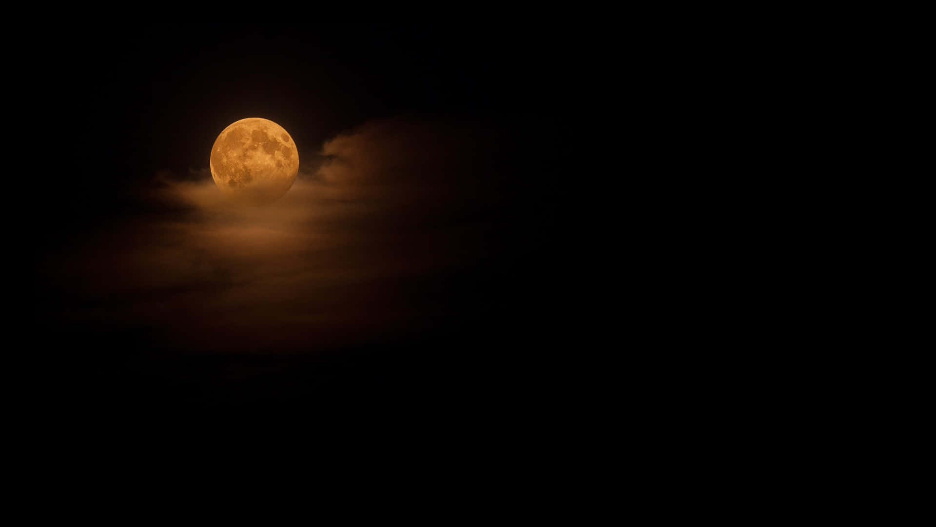 黑夜 桌布 壁紙 — 一輪明亮的橙色滿月穿過縷縷薄雲，在深邃的黑色夜空中閃耀。