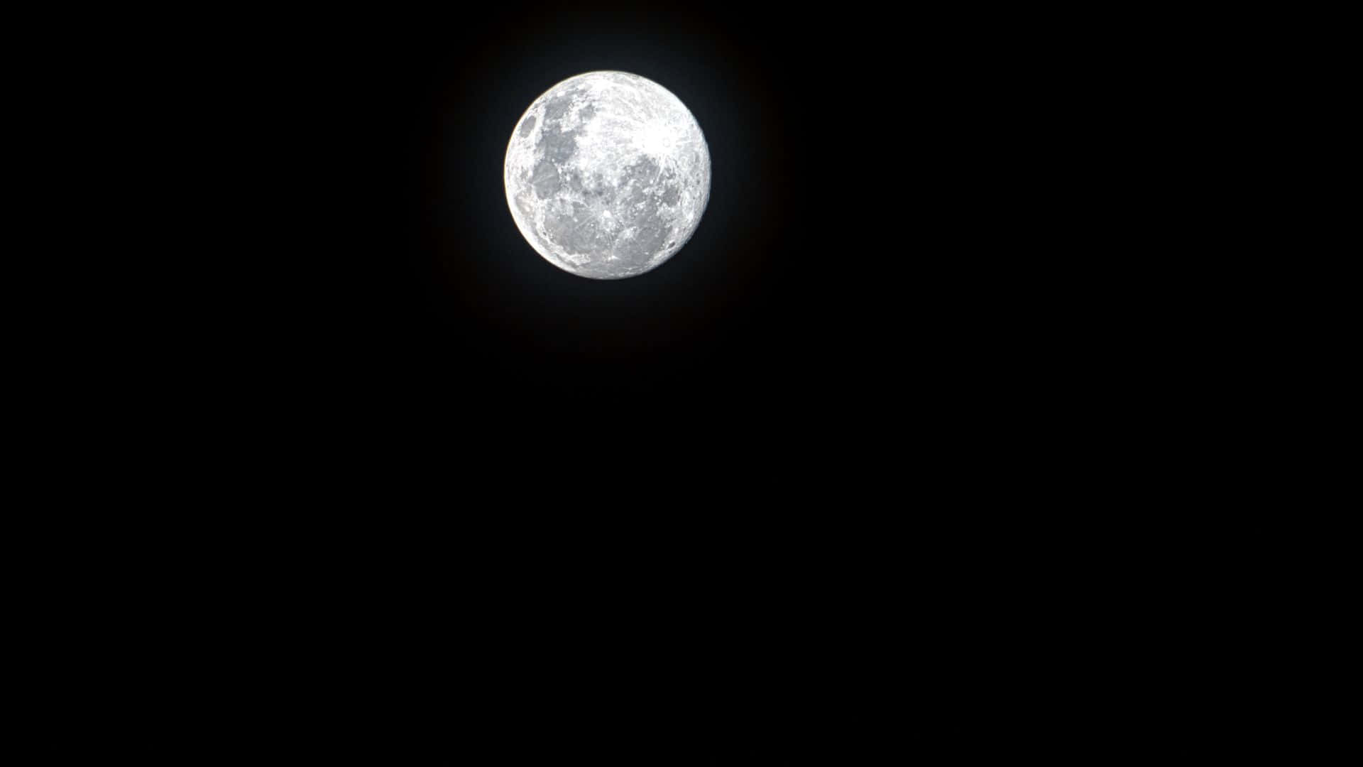 黑夜 桌布 壁紙 — 一輪明亮的滿月，帶有詳細的隕石坑和月海，在漆黑的夜空中閃耀。