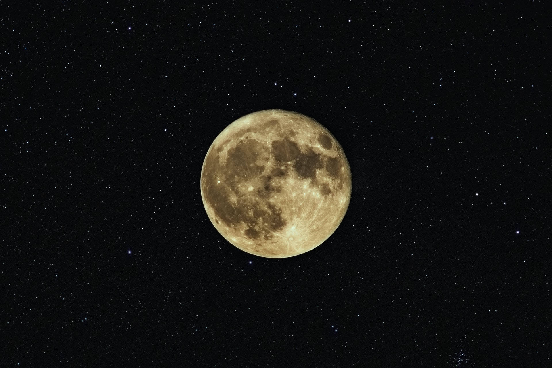luna 桌布 壁紙 — 一輪明亮的滿月主宰著繁星點點的夜空，可見的隕石坑和月海在深邃的黑暗中柔和地發光。