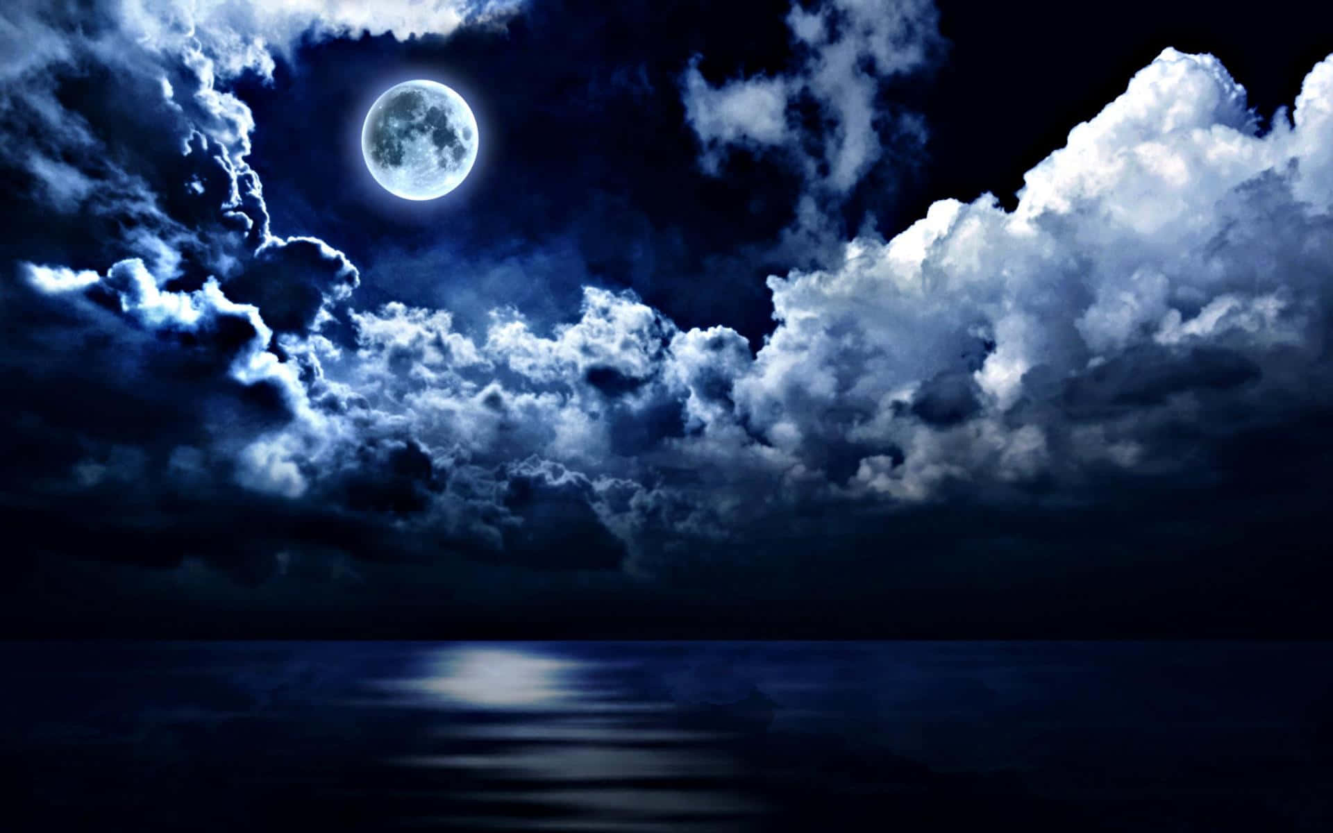 Pretty Moon 桌布 壁紙 — 一輪明亮的滿月在夜間透過戲劇性的雲層在平靜的海洋上投下銀色的光芒。