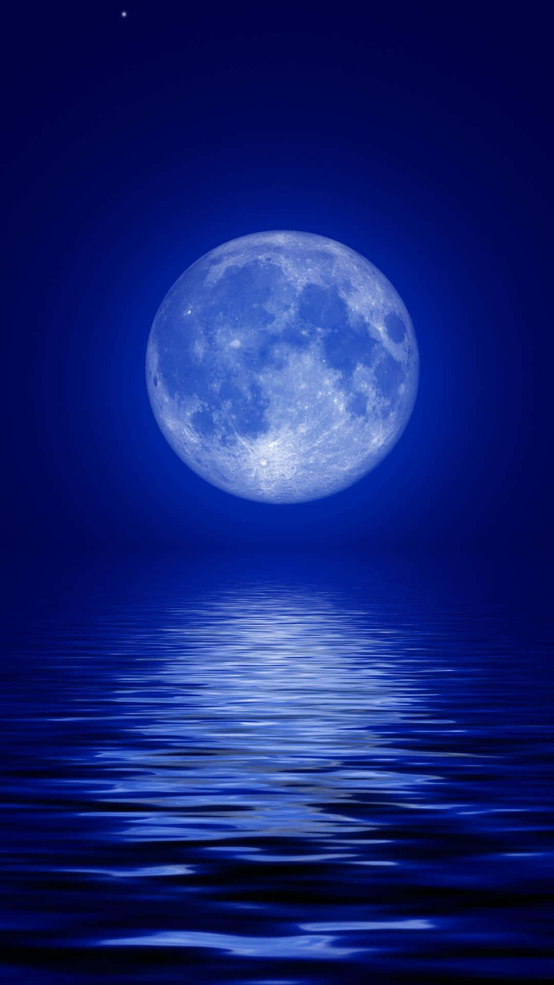 月光 桌布 壁紙 — 一輪明亮的滿月在平靜的水面上閃耀，在深邃的夜空下投射出閃爍的藍色倒影。