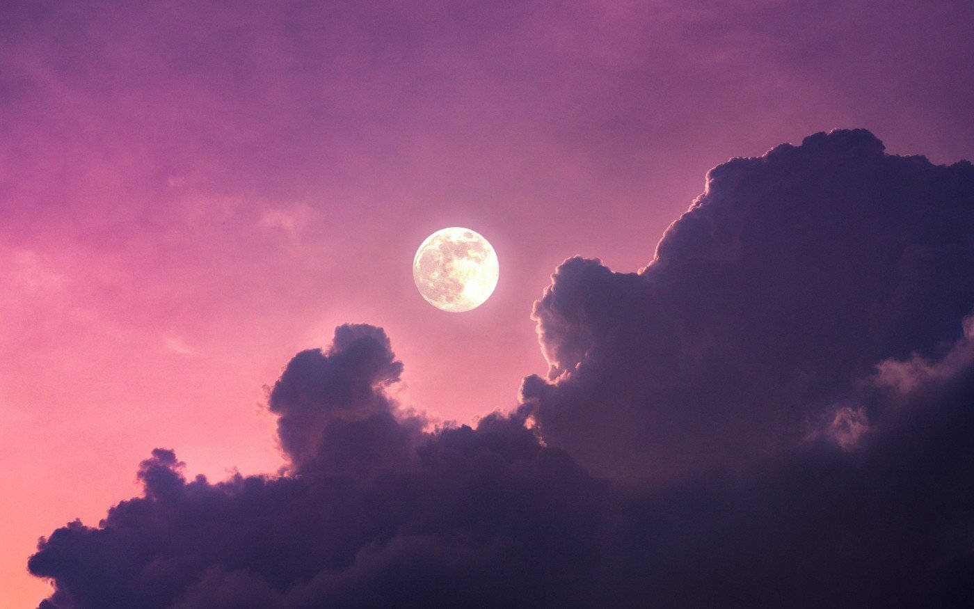 Cloudy Sky 桌布 壁紙 — 一輪明亮的滿月在戲劇性的紫色雲層中閃耀，映襯著充滿活力的粉紅色暮色天空。