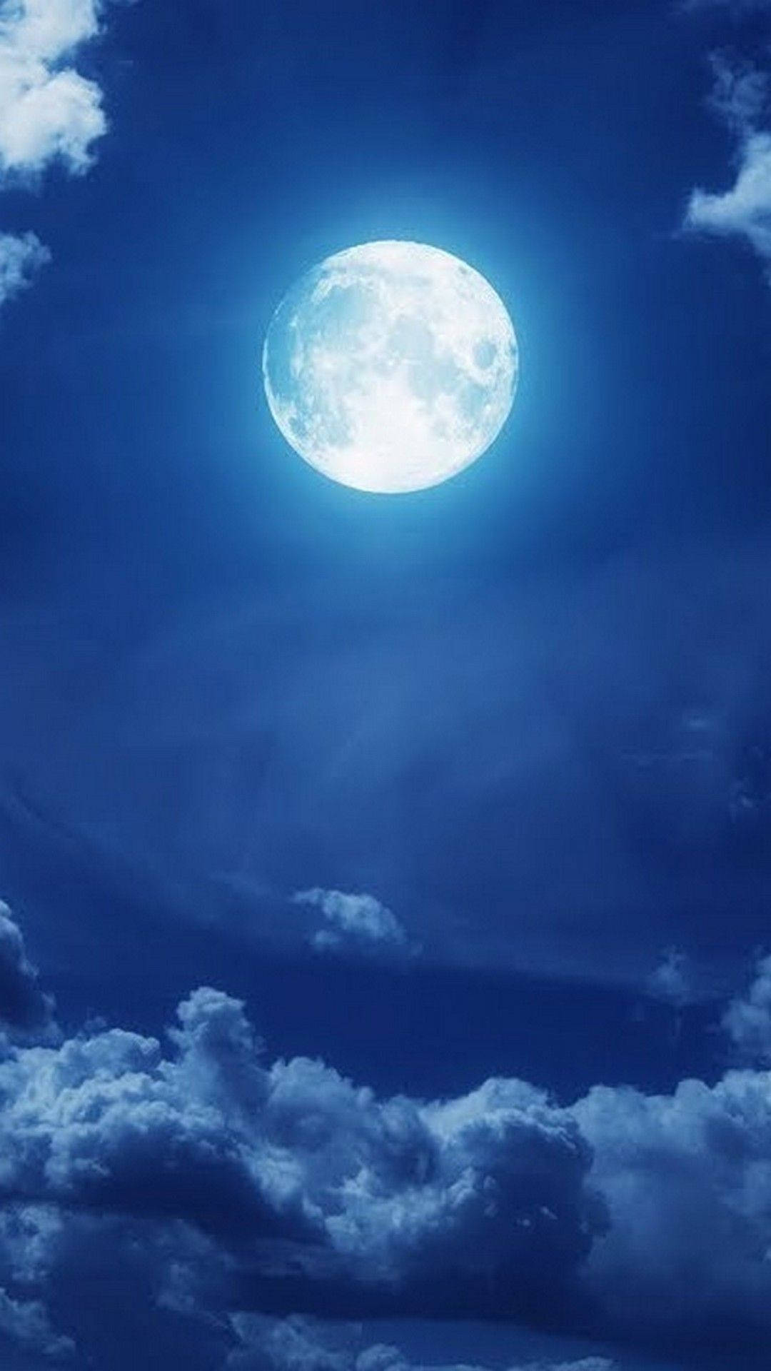 full moon 桌布 壁紙 — 一輪明亮的滿月在深藍色的夜空下閃耀，夜空點綴著柔軟的白雲。