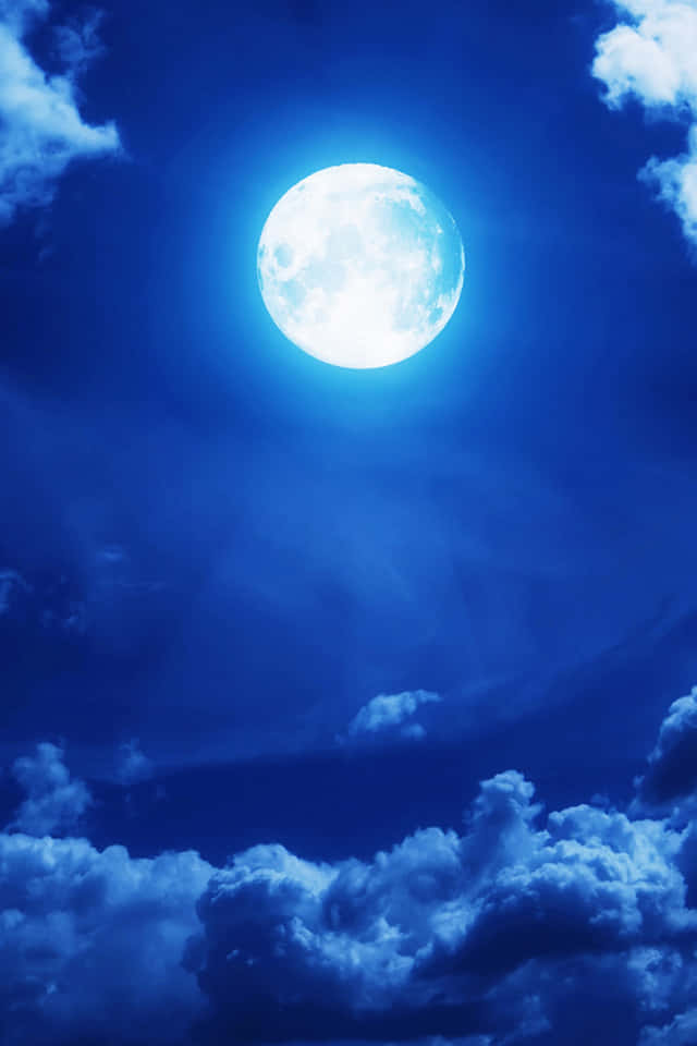 640x960 桌布 壁紙 — 一輪明亮的滿月在深藍色的夜空中閃耀，點綴著柔軟的白雲。