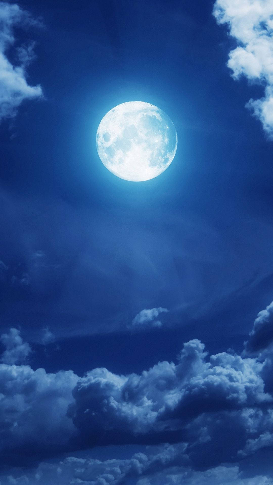 月光 桌布 壁紙 — 一輪明亮的滿月在深藍色的夜空中閃耀，夜空中散佈著柔軟的白雲。