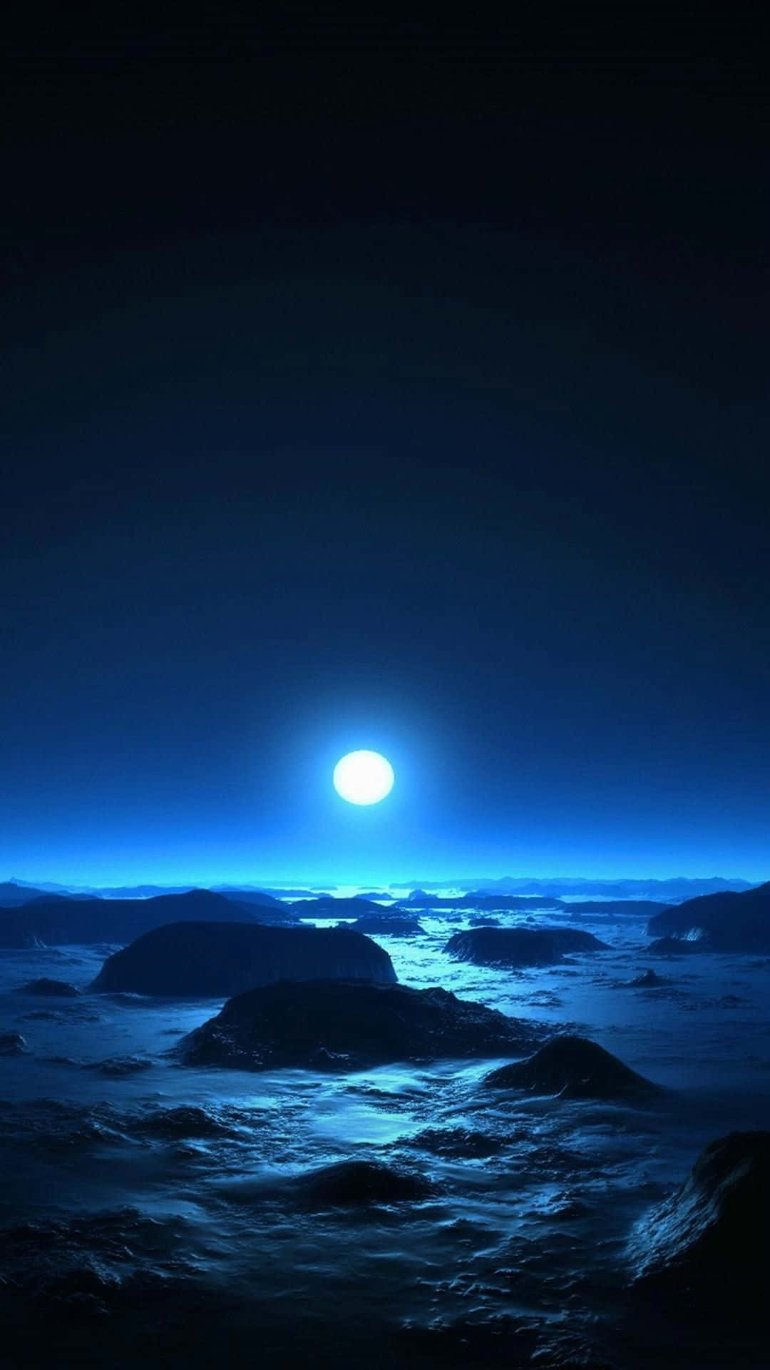 Cool Moon 桌布 壁紙 — 一輪明亮的滿月在深邃的夜空下，將寧靜的藍色光芒投射在崎嶇的冰雪景觀上。