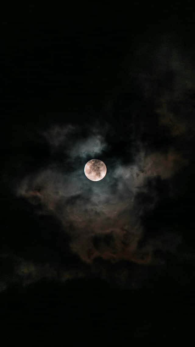 Moon iPhone 桌布 壁紙 — 一輪明亮的滿月在深邃的夜空中穿過旋轉的烏雲閃耀。