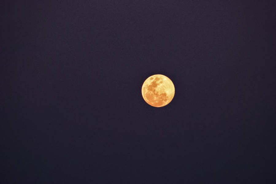 Beautiful Full Moon 桌布 壁紙 — 一輪明亮的滿月在深靛藍色的夜空中溫暖地發光，沒有雲或星星可見。