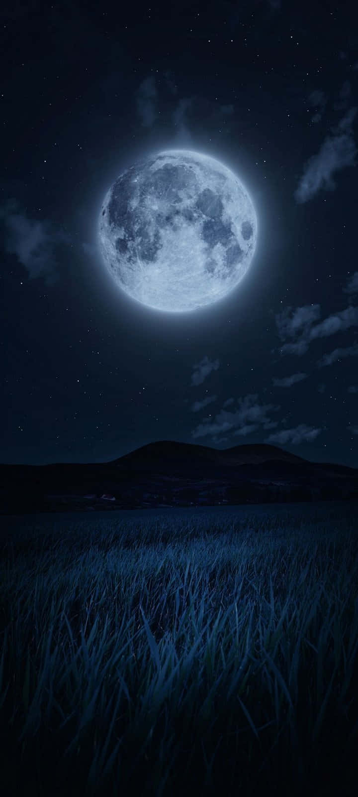 Moon Night 桌布 壁紙 — 一輪明亮的滿月在繁星點點的夜空中，在草地和遠山之上投下清冷的藍色光芒。