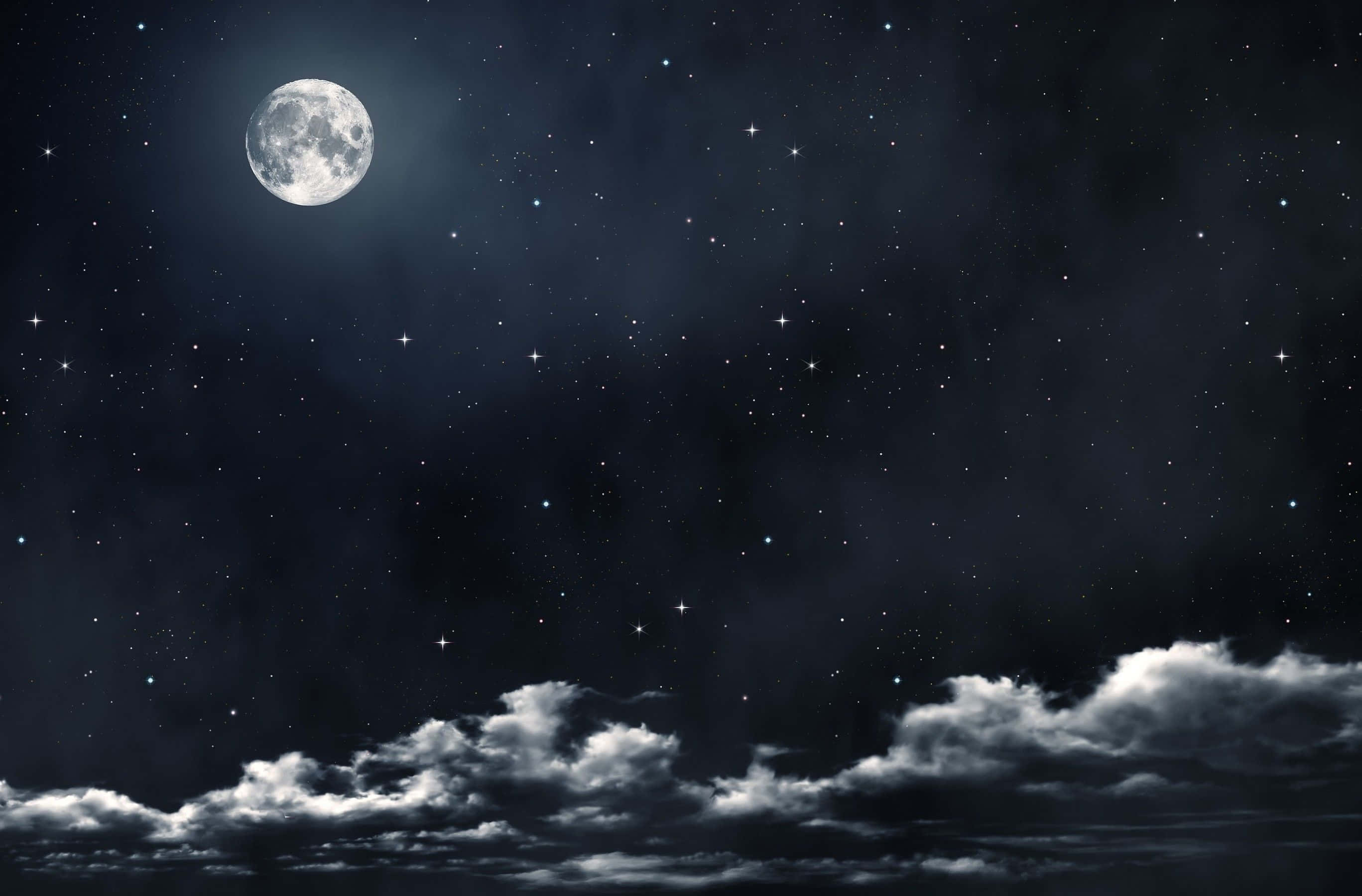 月光 桌布 壁紙 — 一輪明亮的滿月在繁星點點的夜空中發光，下方有縷縷雲彩飄動。