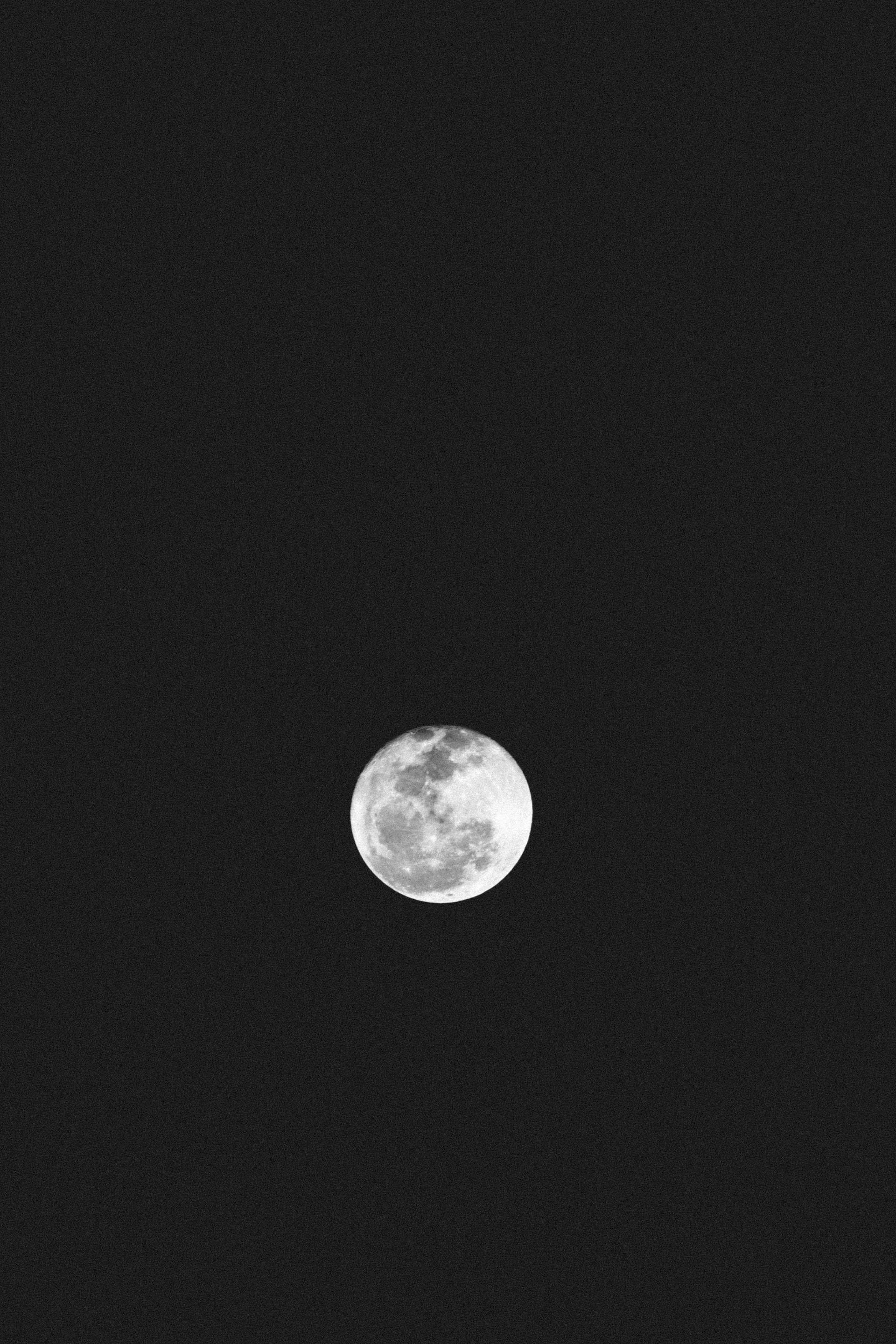 夜空 桌布 壁紙 — 一輪明亮的滿月孤獨地懸掛在深邃的黑色夜空中，可見隕石坑和月海。