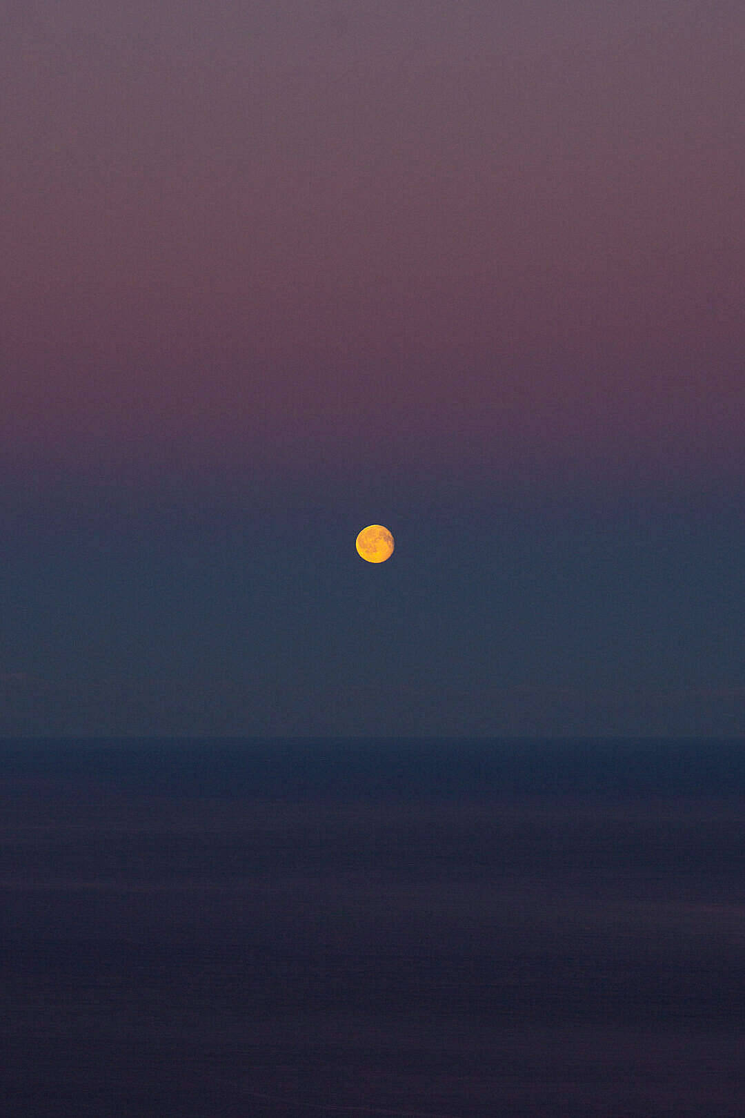 HD Moon 桌布 壁紙 — 一輪明亮的滿月獨自懸掛在平靜的海洋上空，天空是深紫色和藍色的暮色。